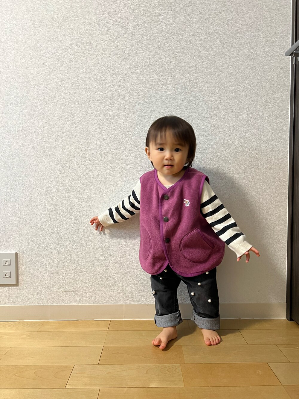 パープル系のベスト、ホワイト系のニット/セーター、ブラック系のその他パンツを着用したキッズの秋コーディネートの2枚目の写真