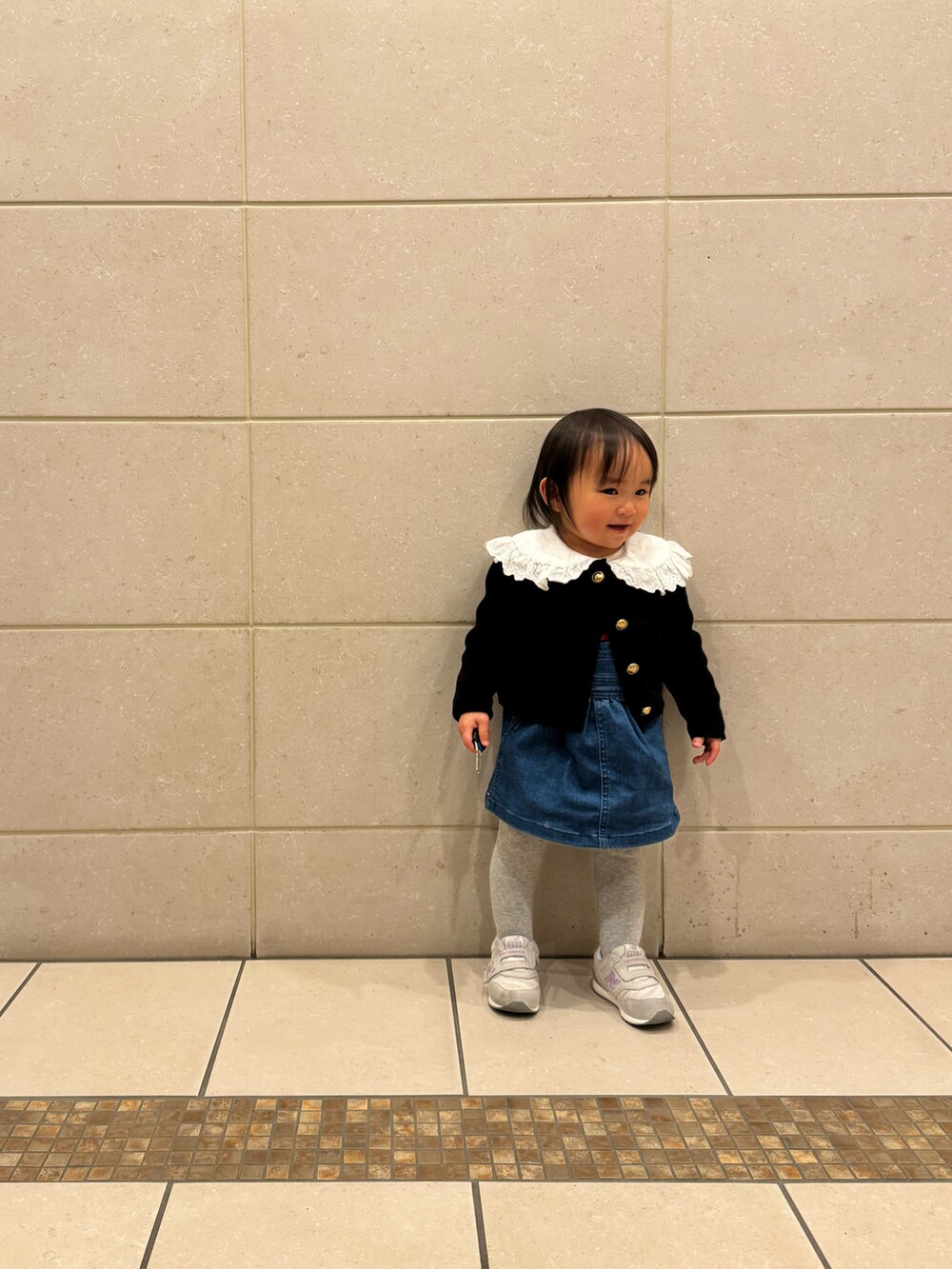 ホワイト系のシャツ/ブラウス、ブラック系のカーディガン/ボレロ、ブルー系のワンピースを着用したキッズの冬コーディネートの2枚目の写真