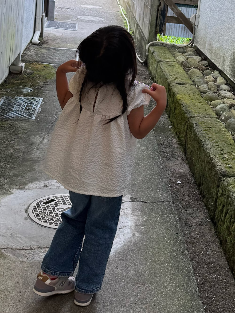 ホワイト系のトップス、ブルー系のデニムパンツを着用したキッズの秋コーディネートの2枚目の写真