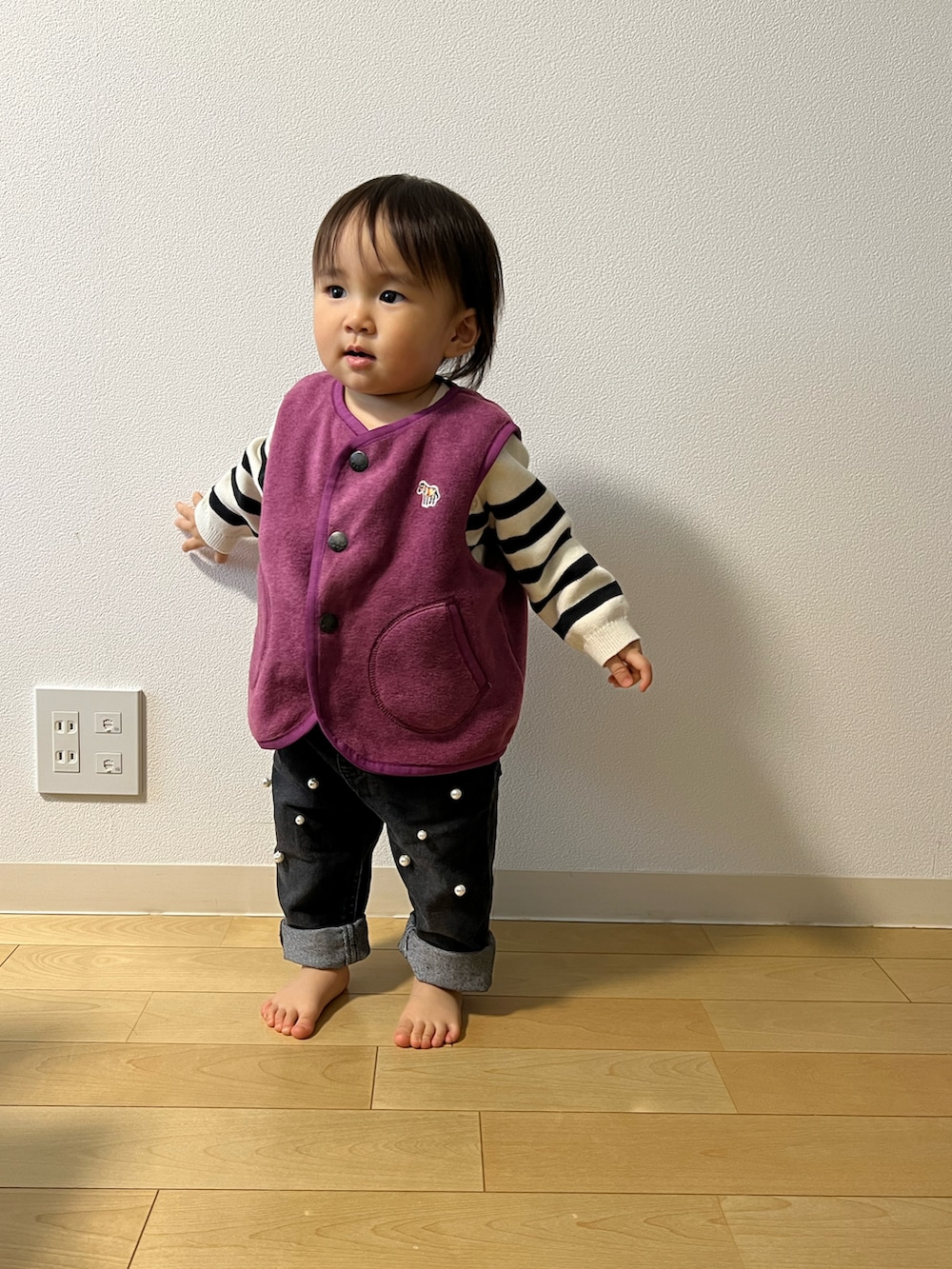 パープル系のベスト、ホワイト系のニット/セーター、ブラック系のその他パンツを着用したキッズの秋コーディネートの4枚目の写真