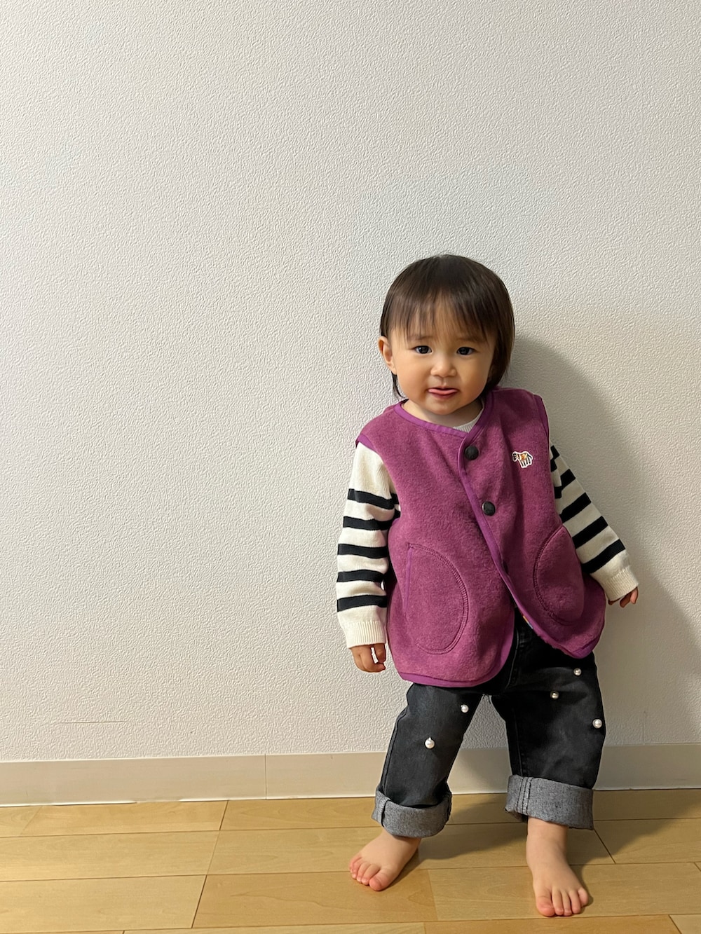 パープル系のベスト、ホワイト系のニット/セーター、ブラック系のその他パンツを着用したキッズの秋コーディネートの3枚目の写真