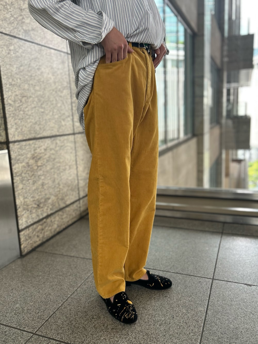 イエロー系のパンツ、ブラウン系のメガネを着用したメンズの秋コーディネートの2枚目の写真