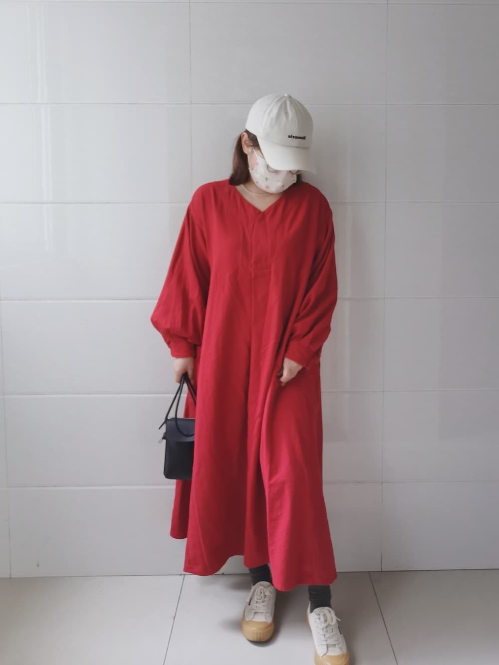 レッド系のワンピース、ブラック系のショルダーバッグを着用したレディースの春コーディネートの3枚目の写真