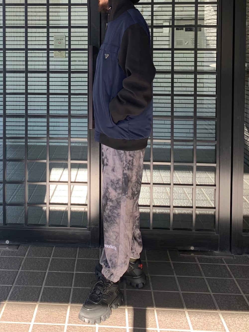 ブルー系のブルゾン、ブラック系のスニーカーを着用したメンズの冬コーディネートの2枚目の写真