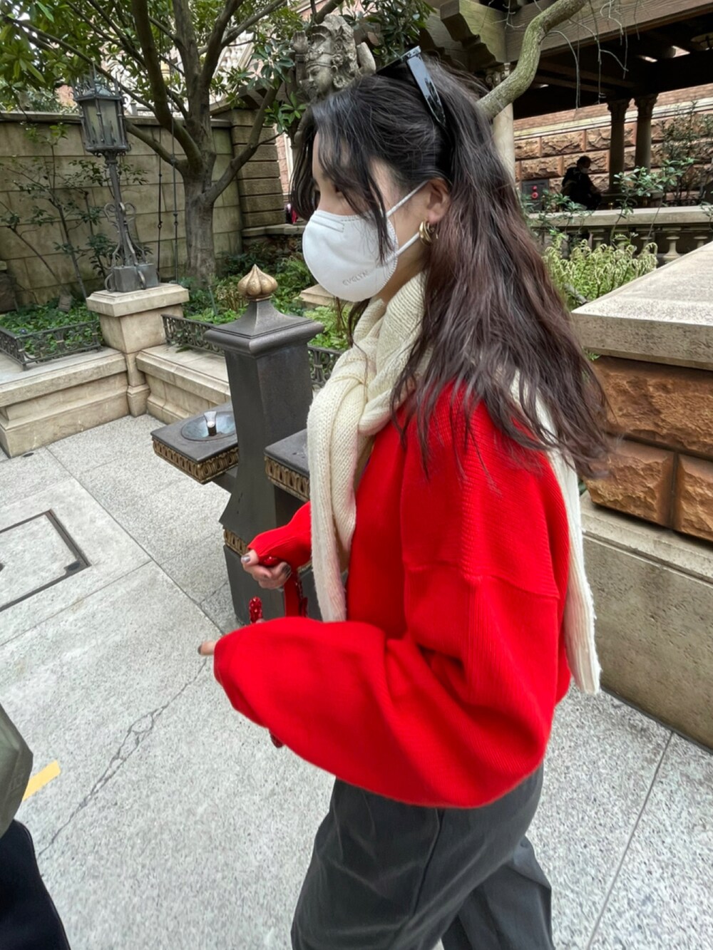 ホワイト系のスニーカー、グレー系のスラックス、レッド系のスウェットを着用したレディースの春コーディネートの3枚目の写真