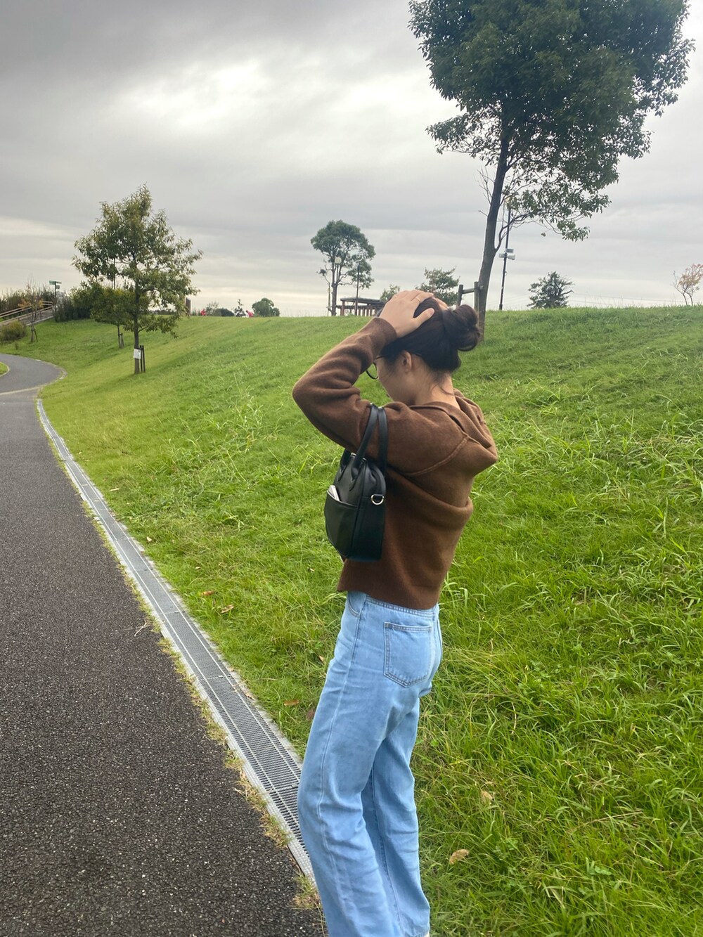 ブラック系のバッグを着用したレディースの秋コーディネートの3枚目の写真