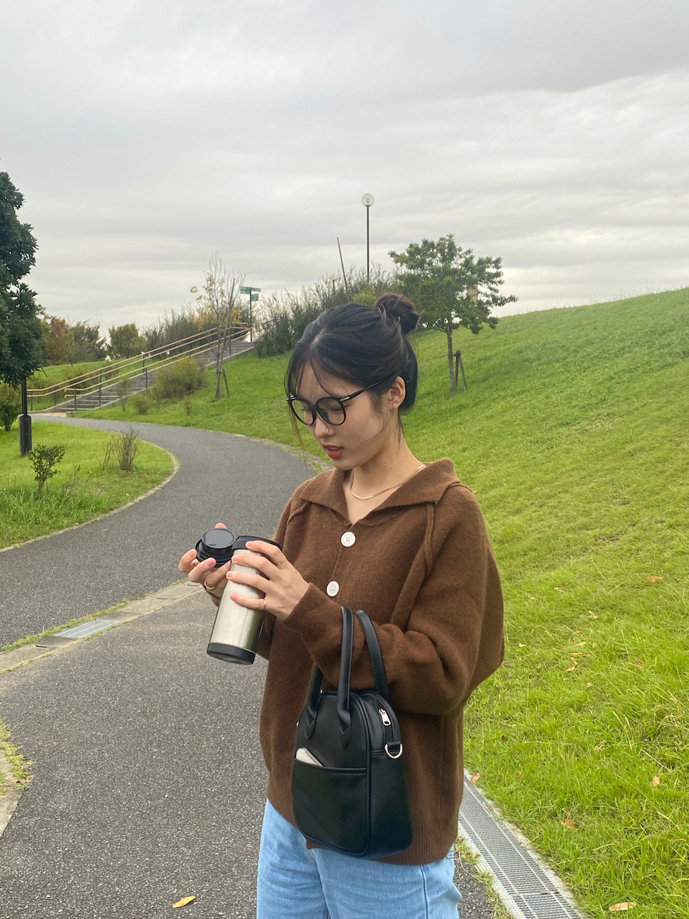 ブラック系のバッグを着用したレディースの秋コーディネートの2枚目の写真