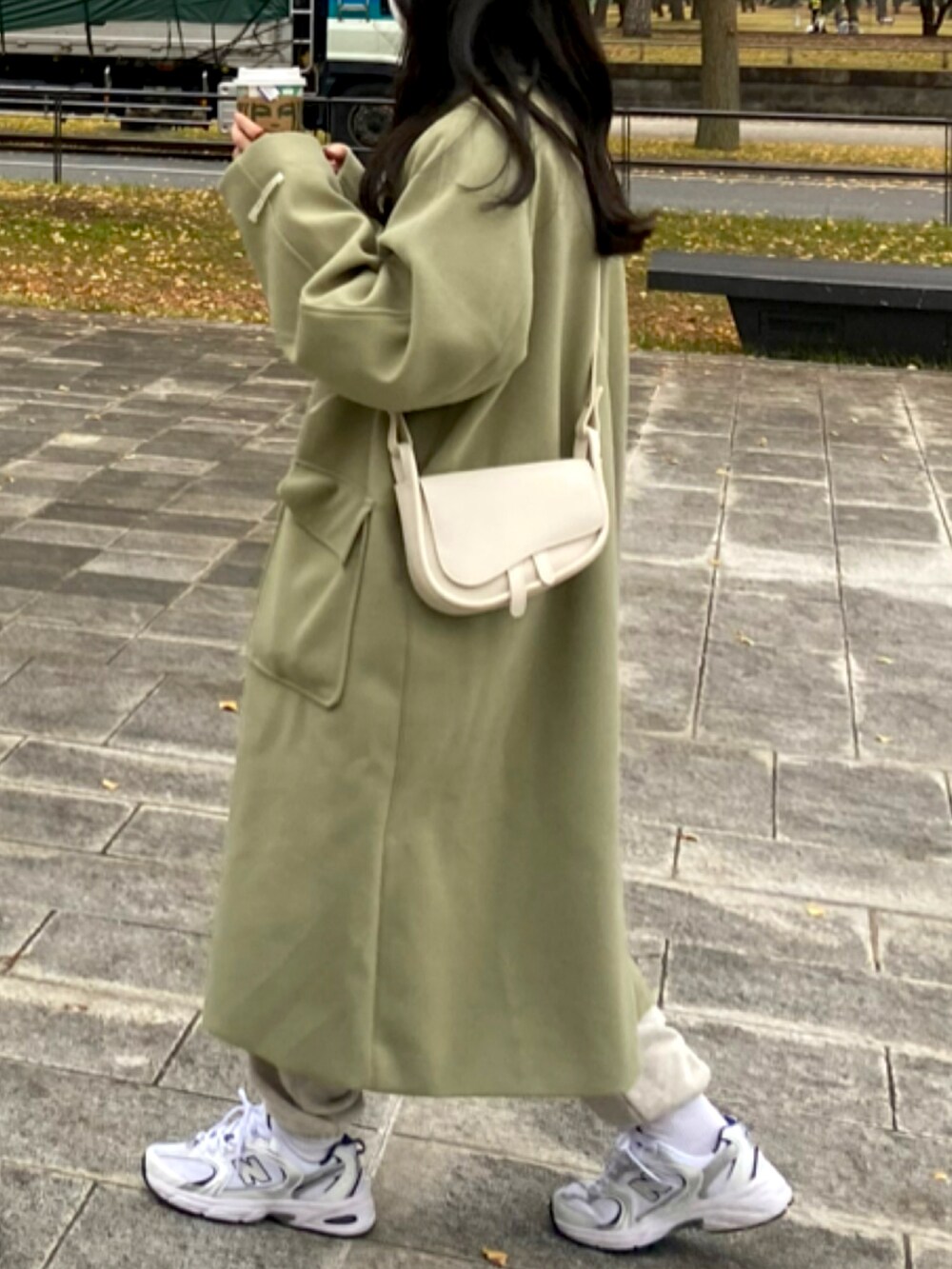 ホワイト系のスニーカー、グリーン系のダウンジャケット/コートを着用したレディースの秋コーディネートの3枚目の写真