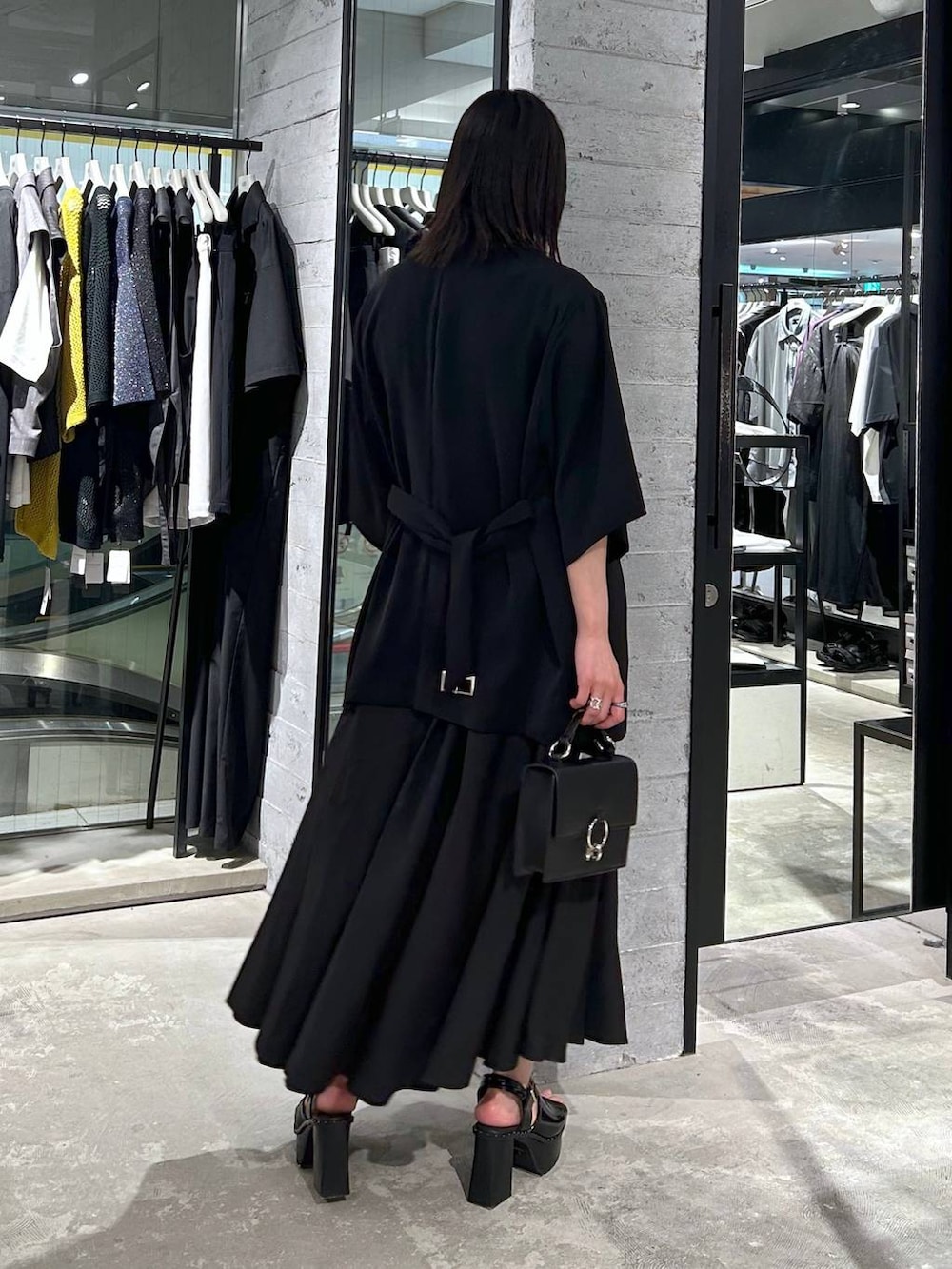 ブラック系のサンダル、ブラック系のテーラードジャケット、ブラック系のショルダーバッグを着用したレディースの春コーディネートの5枚目の写真