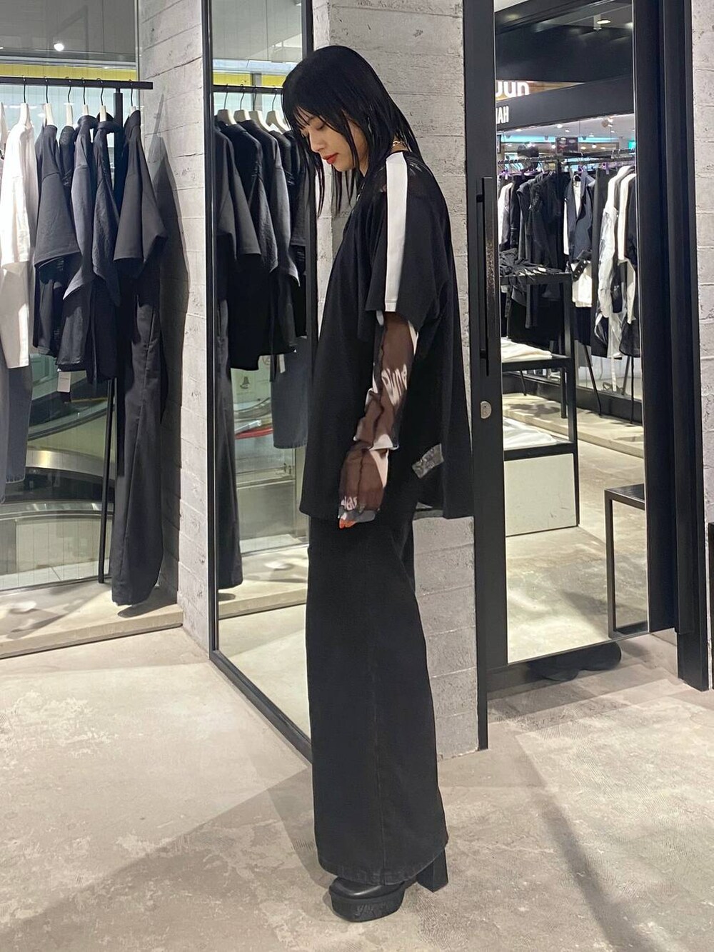 ブラック系のデニムパンツ、ブラック系のショルダーバッグ、ブラック系のパンプスを着用したレディースの夏コーディネートの4枚目の写真