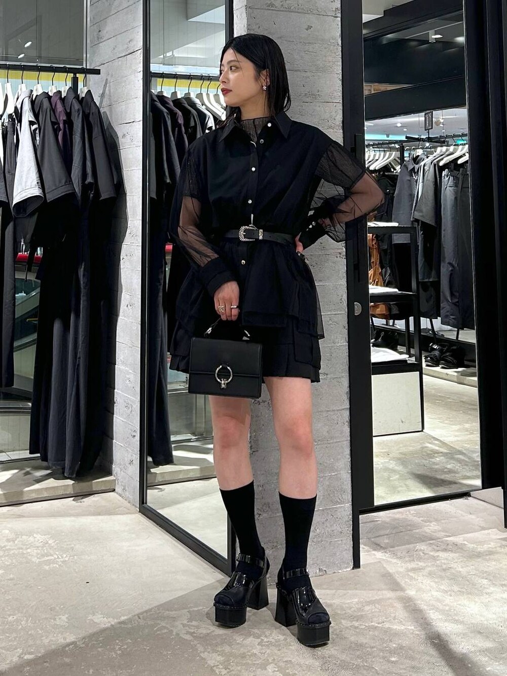 ブラック系のサンダル、ブラック系のカーゴパンツ、ブラック系のショルダーバッグを着用したレディースの春コーディネートの2枚目の写真