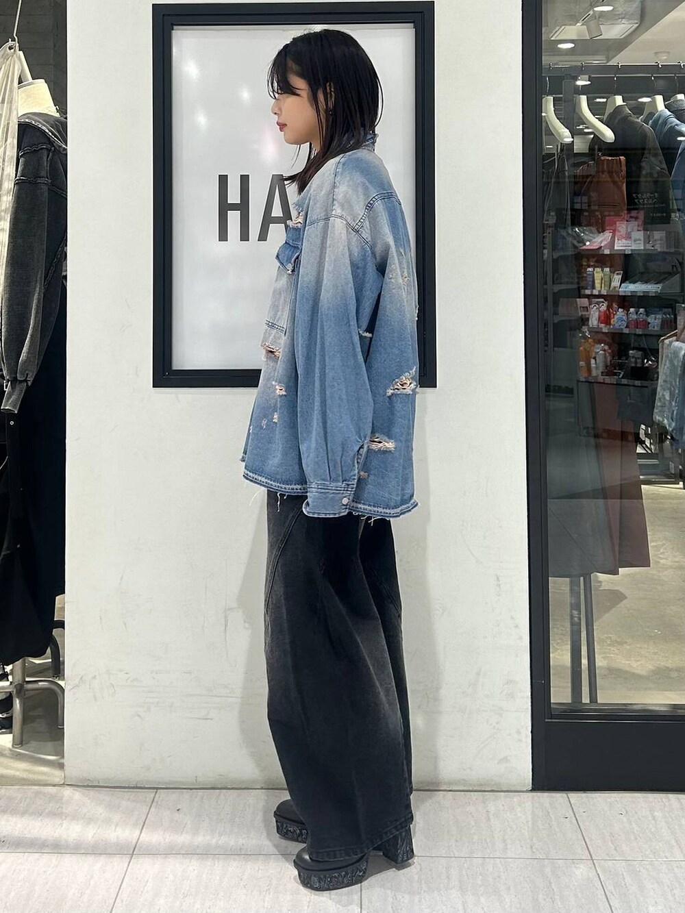 ブラック系のトートバッグ、ブラック系のデニムパンツ、ブラック系のパンプスを着用したレディースの冬コーディネートの4枚目の写真