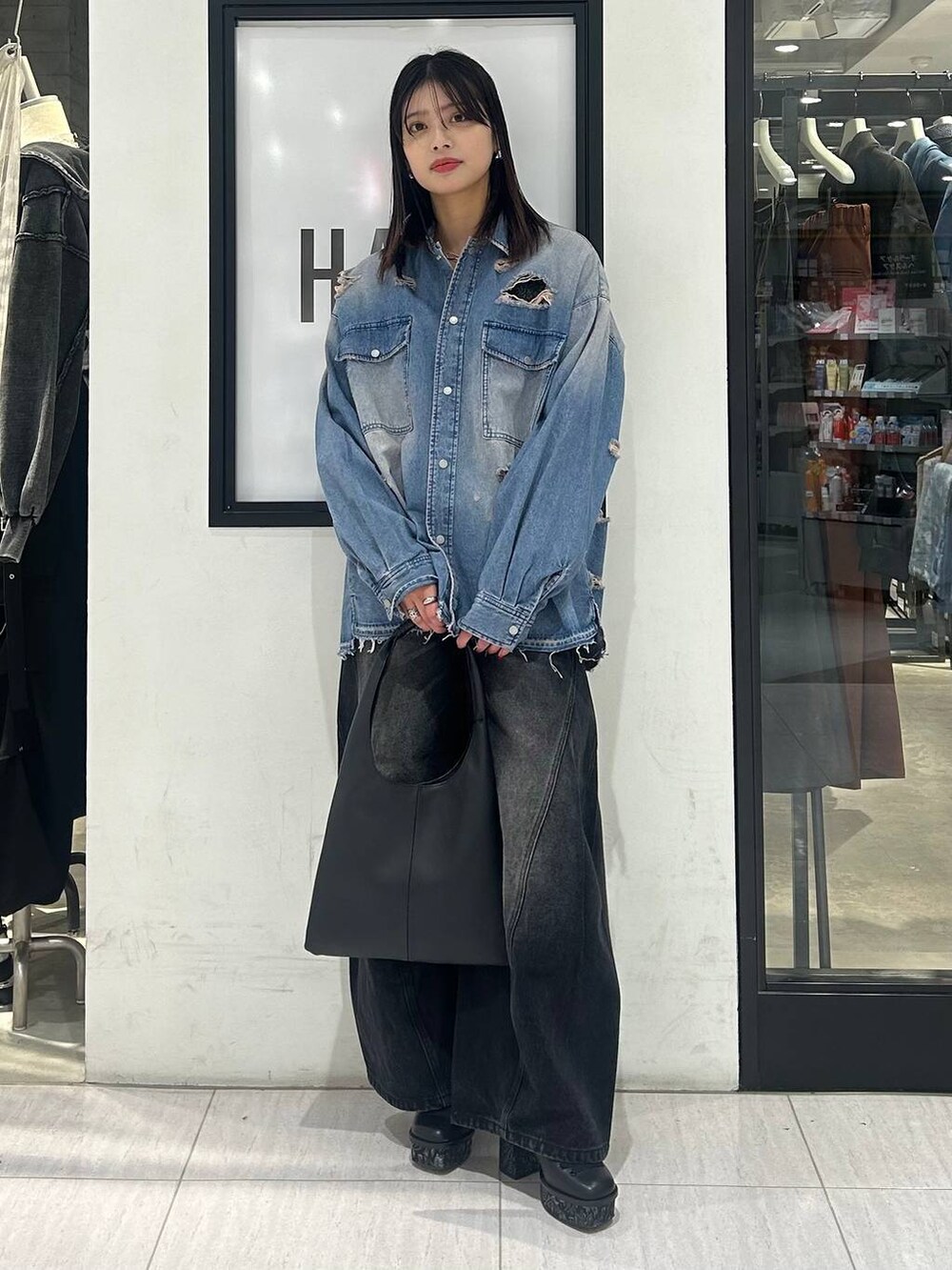 ブラック系のトートバッグ、ブラック系のデニムパンツ、ブラック系のパンプスを着用したレディースの冬コーディネートの3枚目の写真