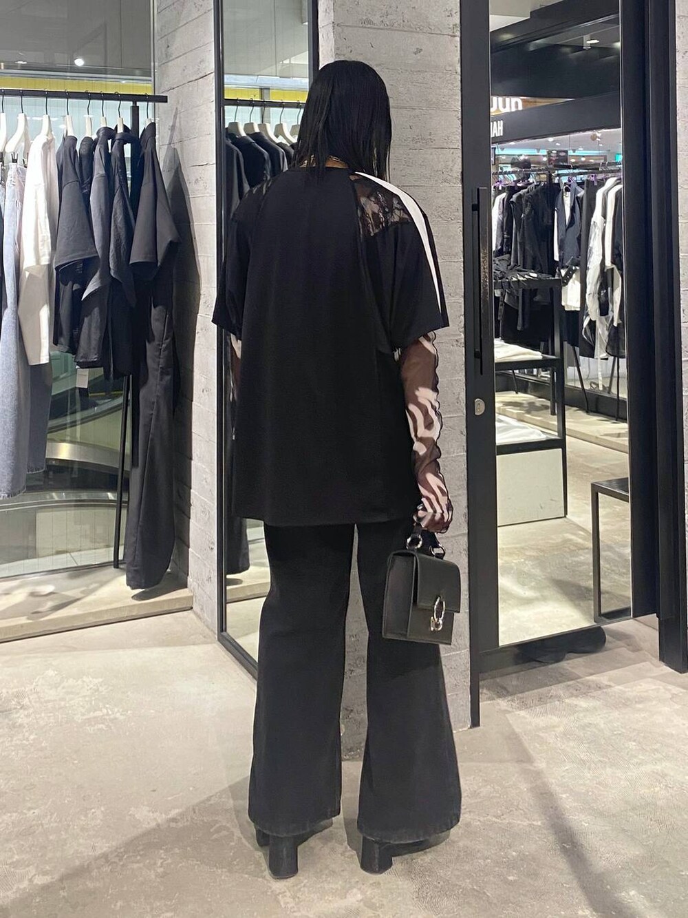 ブラック系のデニムパンツ、ブラック系のショルダーバッグ、ブラック系のパンプスを着用したレディースの夏コーディネートの5枚目の写真