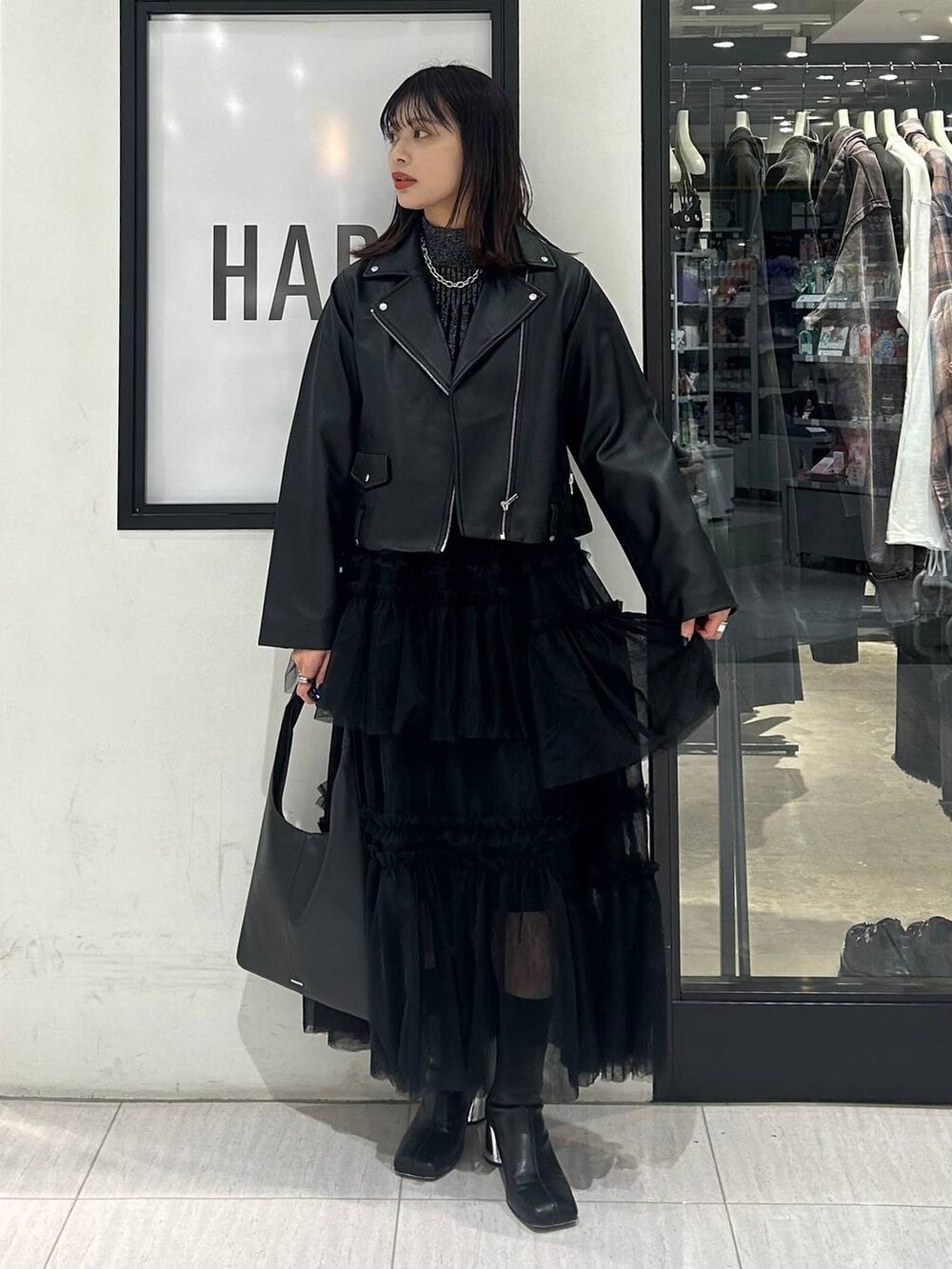 ブラック系のトートバッグ、ブラック系のニット/セーター、ブラック系のブーツを着用したレディースの秋コーディネートの2枚目の写真