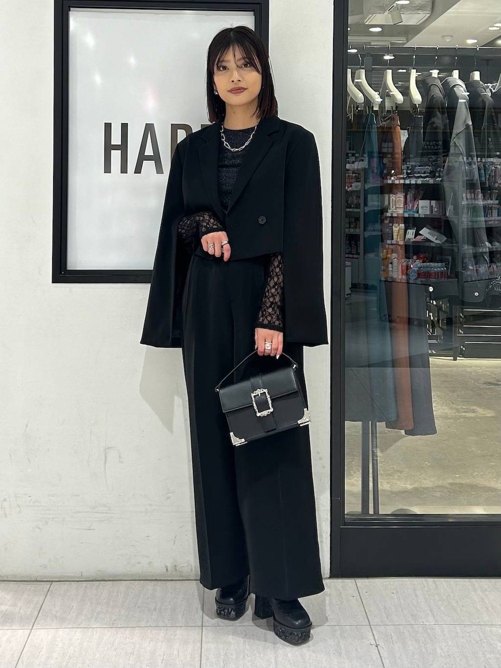 ブラック系のショルダーバッグ、ブラック系のパンプス、ブラック系のテーラードジャケットを着用したレディースの春コーディネートの3枚目の写真