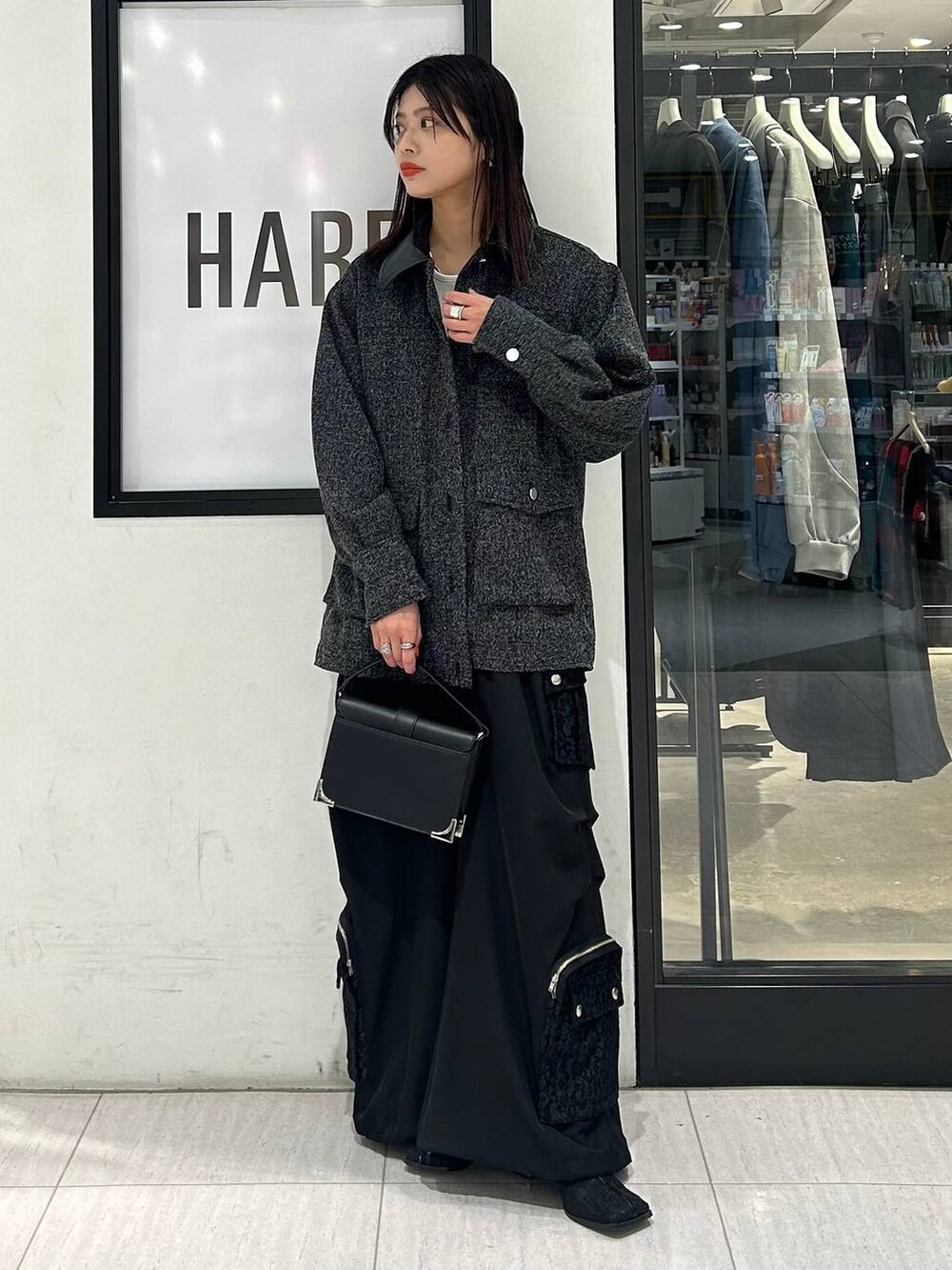 ブラック系のブーツ、ホワイト系のTシャツ/カットソー、ブラック系のショルダーバッグを着用したレディースの冬コーディネートの2枚目の写真