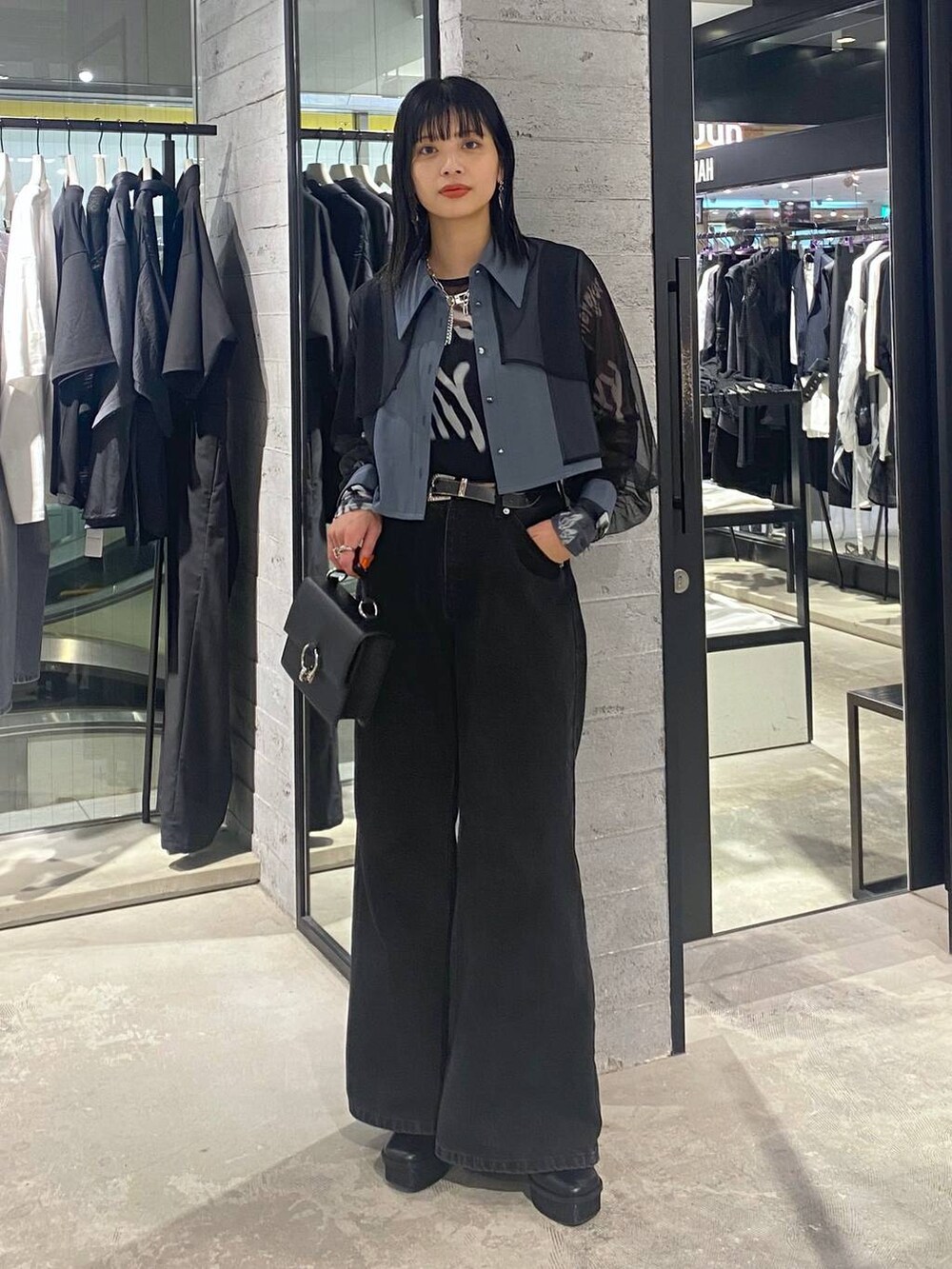 ブラック系のデニムパンツ、ブラック系のショルダーバッグ、ブラック系のパンプスを着用したレディースの夏コーディネートの2枚目の写真