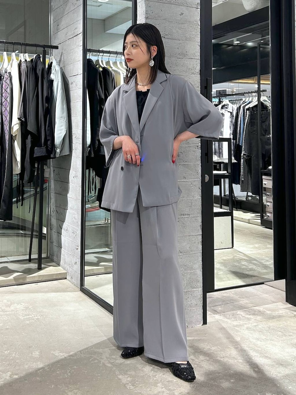 グレー系のスラックス、ブラック系のタンクトップ、ブラック系のパンプスを着用したレディースの春コーディネートの2枚目の写真