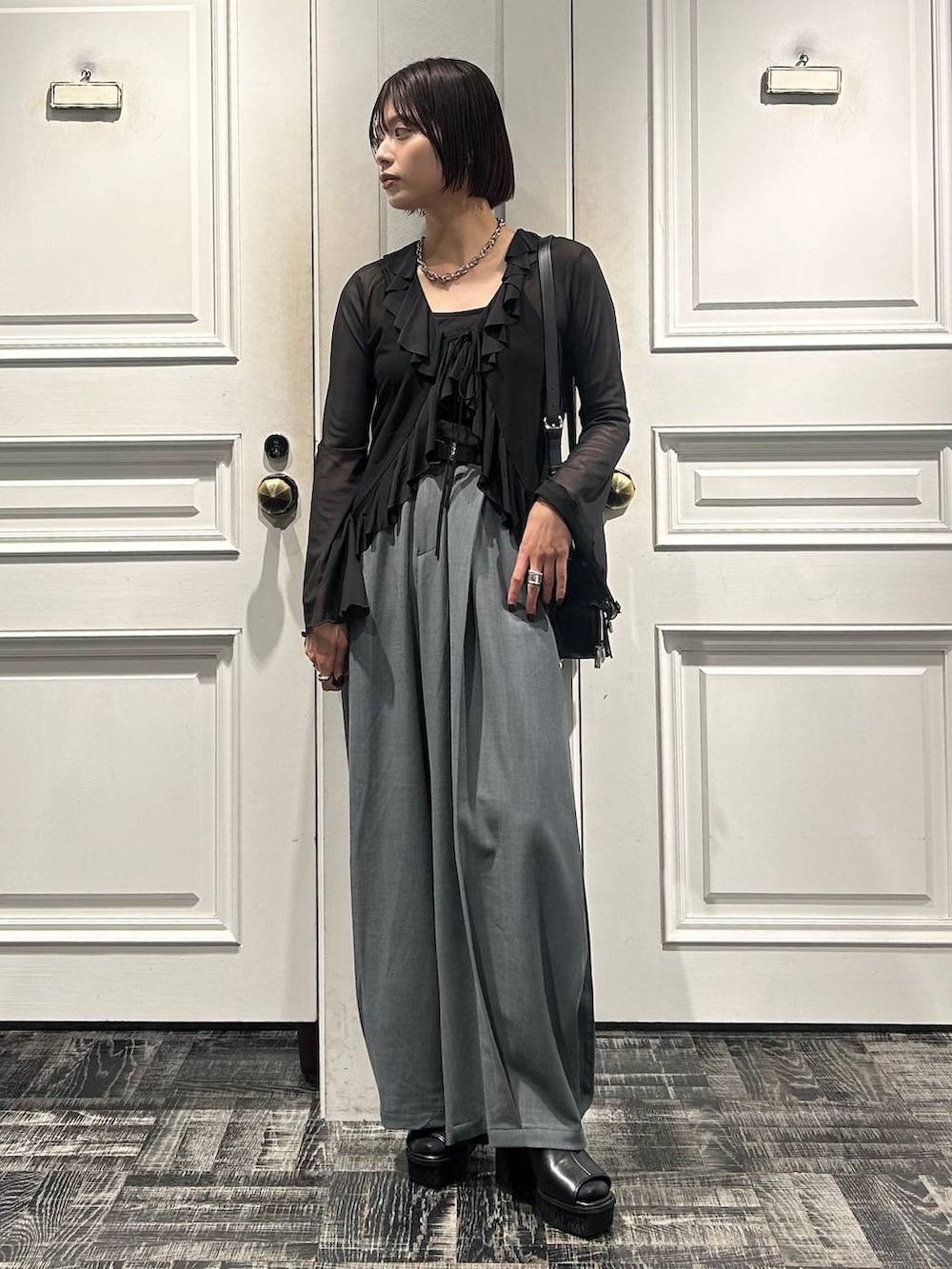 ブラック系のショルダーバッグ、グレー系のサンダル、ブラック系のカーディガン/ボレロを着用したレディースの春コーディネートの2枚目の写真