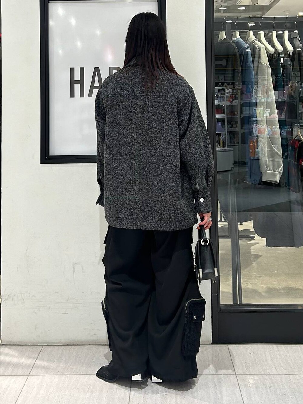 ブラック系のブーツ、ホワイト系のTシャツ/カットソー、ブラック系のショルダーバッグを着用したレディースの冬コーディネートの5枚目の写真
