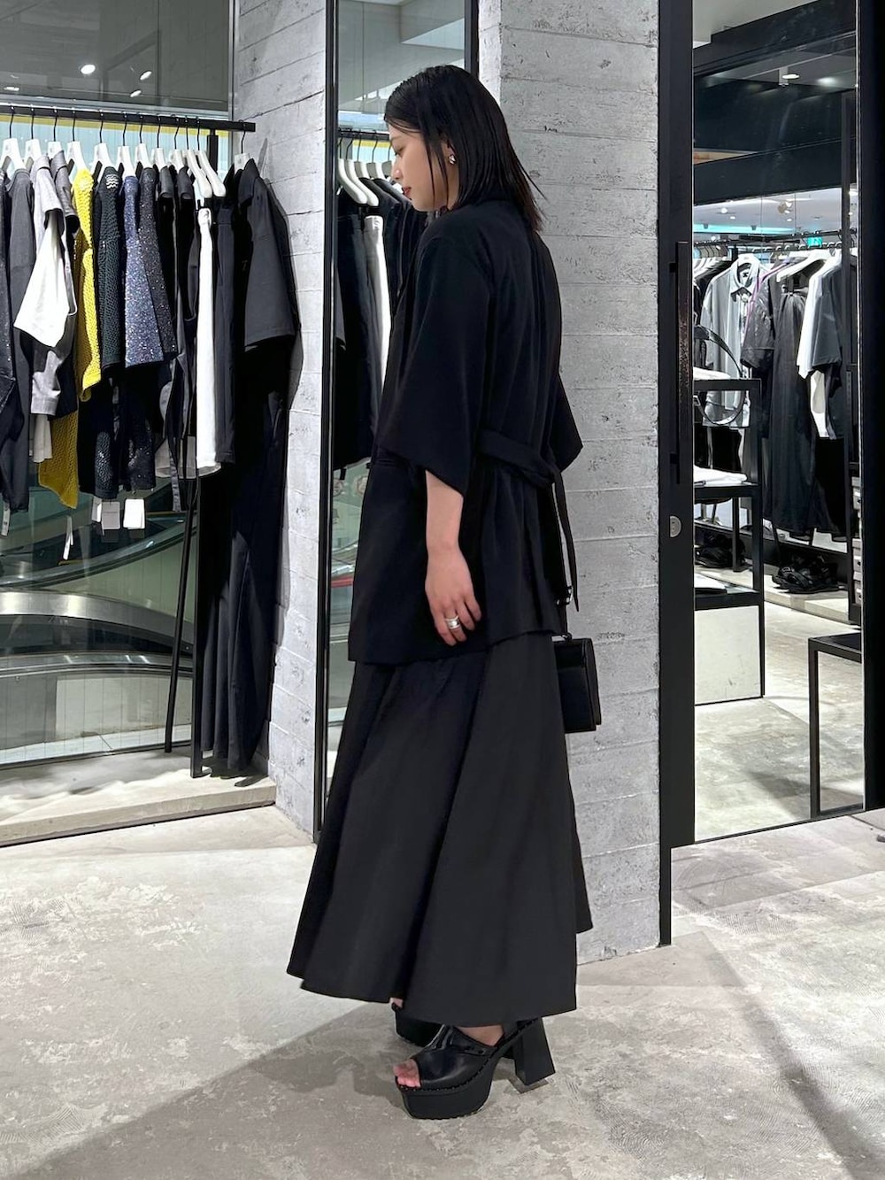 ブラック系のサンダル、ブラック系のテーラードジャケット、ブラック系のショルダーバッグを着用したレディースの春コーディネートの4枚目の写真