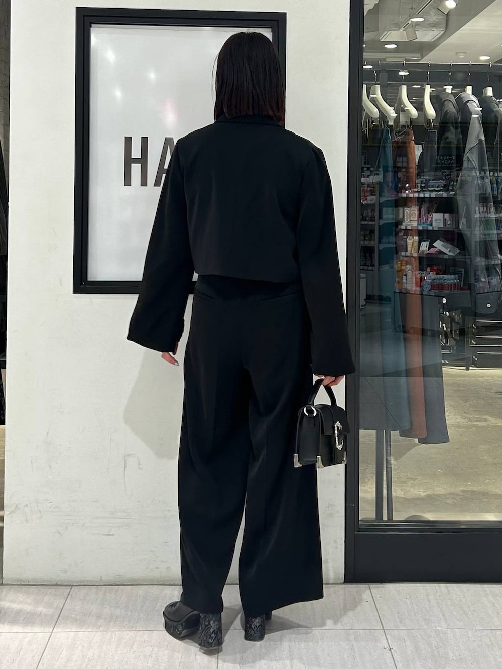 ブラック系のショルダーバッグ、ブラック系のパンプス、ブラック系のテーラードジャケットを着用したレディースの春コーディネートの5枚目の写真