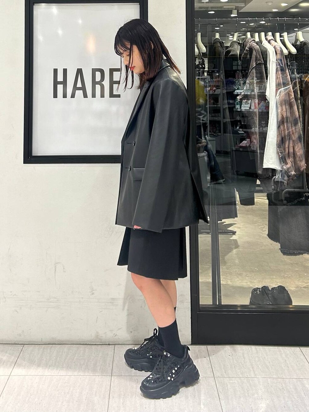 ブラック系のスニーカー、ブラック系のTシャツ/カットソー、グレー系のテーラードジャケットを着用したレディースの秋コーディネートの3枚目の写真
