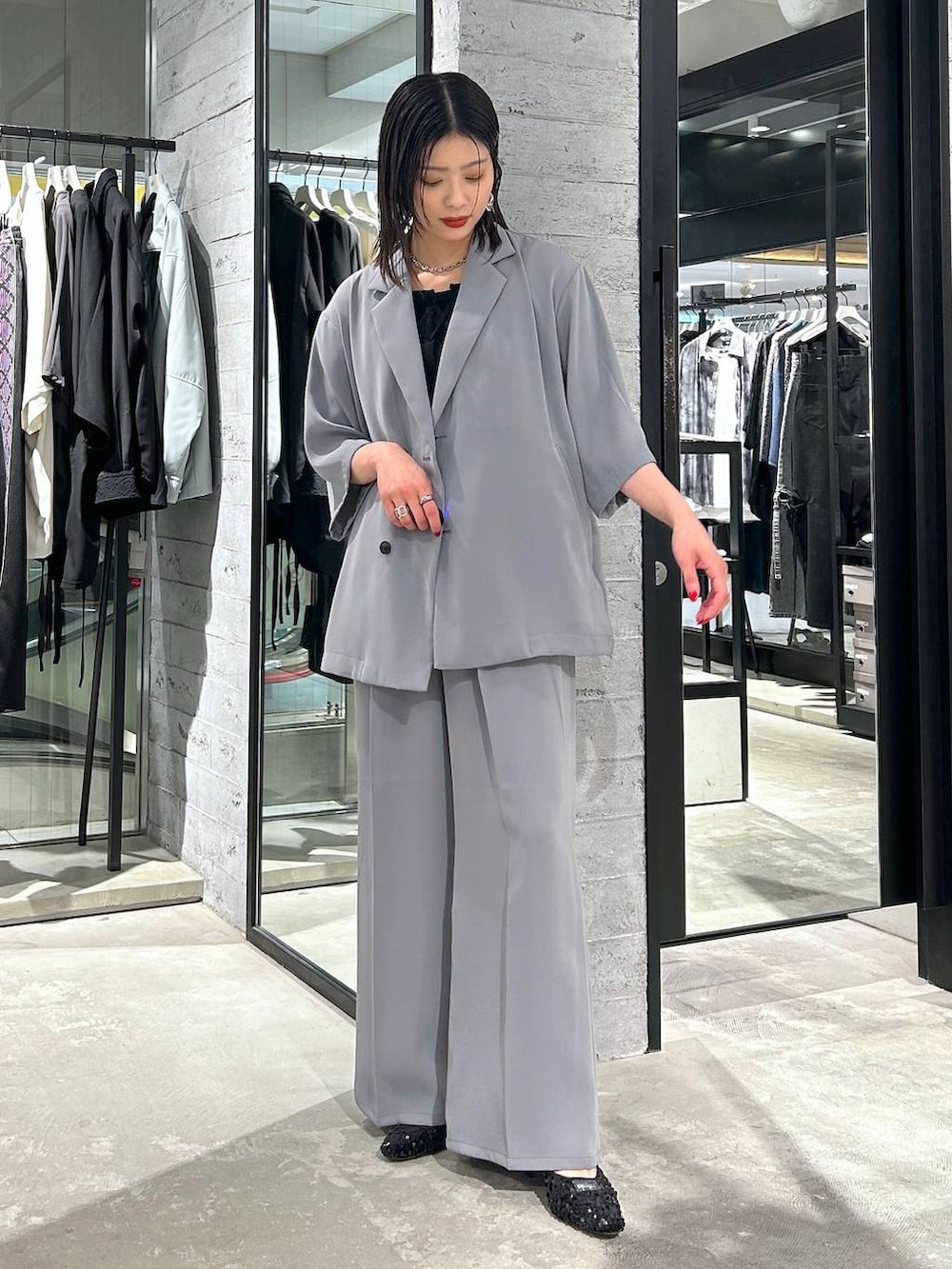 グレー系のスラックス、ブラック系のタンクトップ、ブラック系のパンプスを着用したレディースの春コーディネートの3枚目の写真