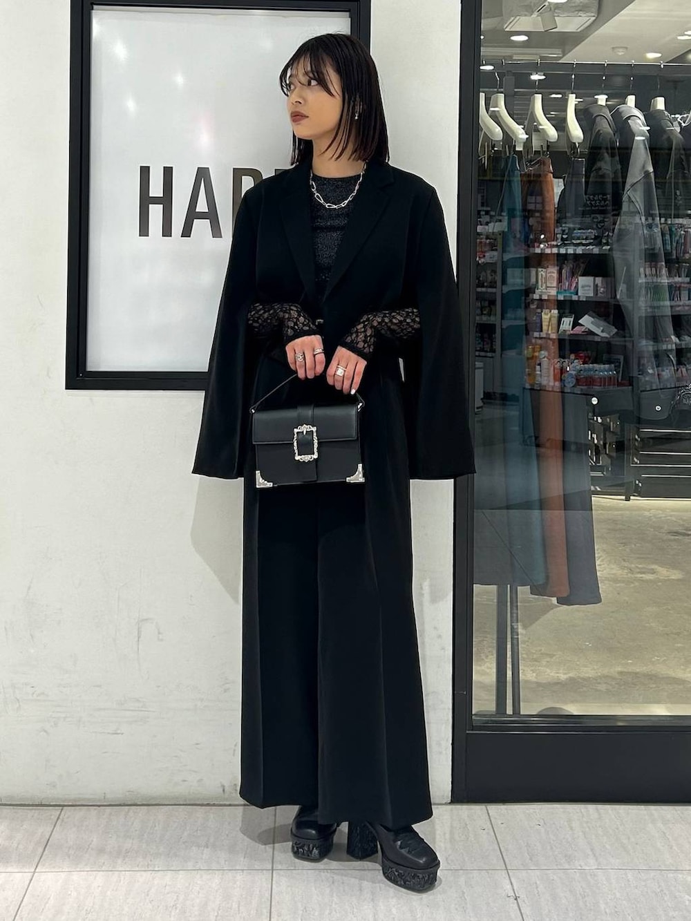 ブラック系のショルダーバッグ、ブラック系のパンプス、ブラック系のテーラードジャケットを着用したレディースの春コーディネートの2枚目の写真