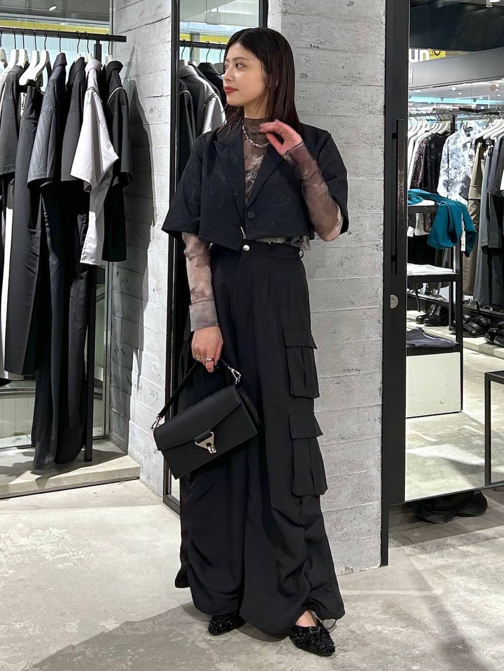 ブラック系のショルダーバッグ、ブラック系のパンプス、ブラック系のTシャツ/カットソーを着用したレディースの春コーディネートの3枚目の写真