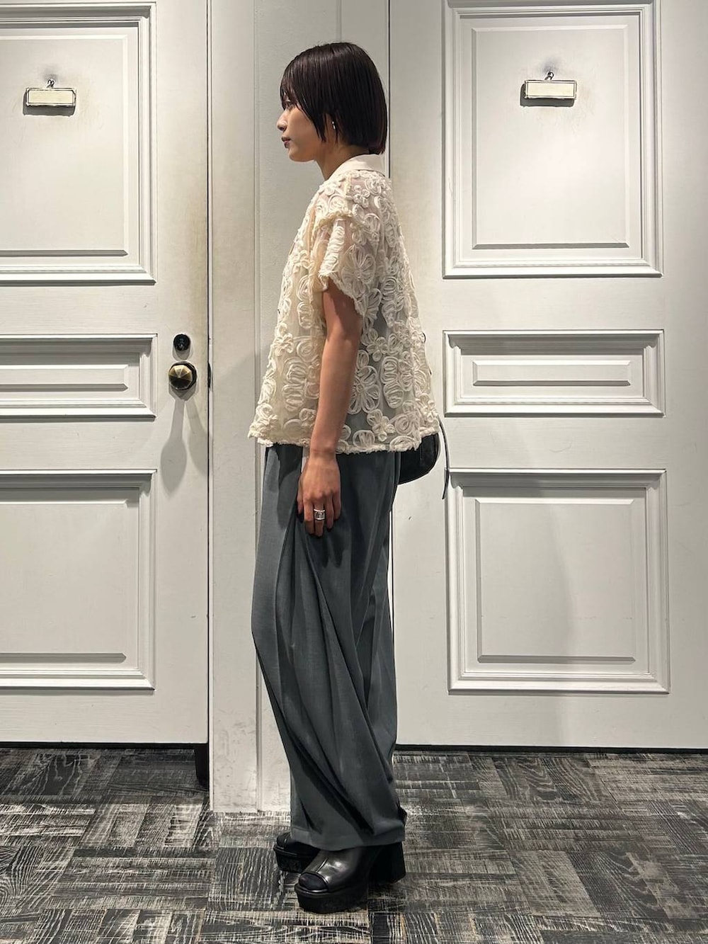 グレー系のショルダーバッグ、グレー系のサンダル、ホワイト系のシャツ/ブラウスを着用したレディースの春コーディネートの3枚目の写真