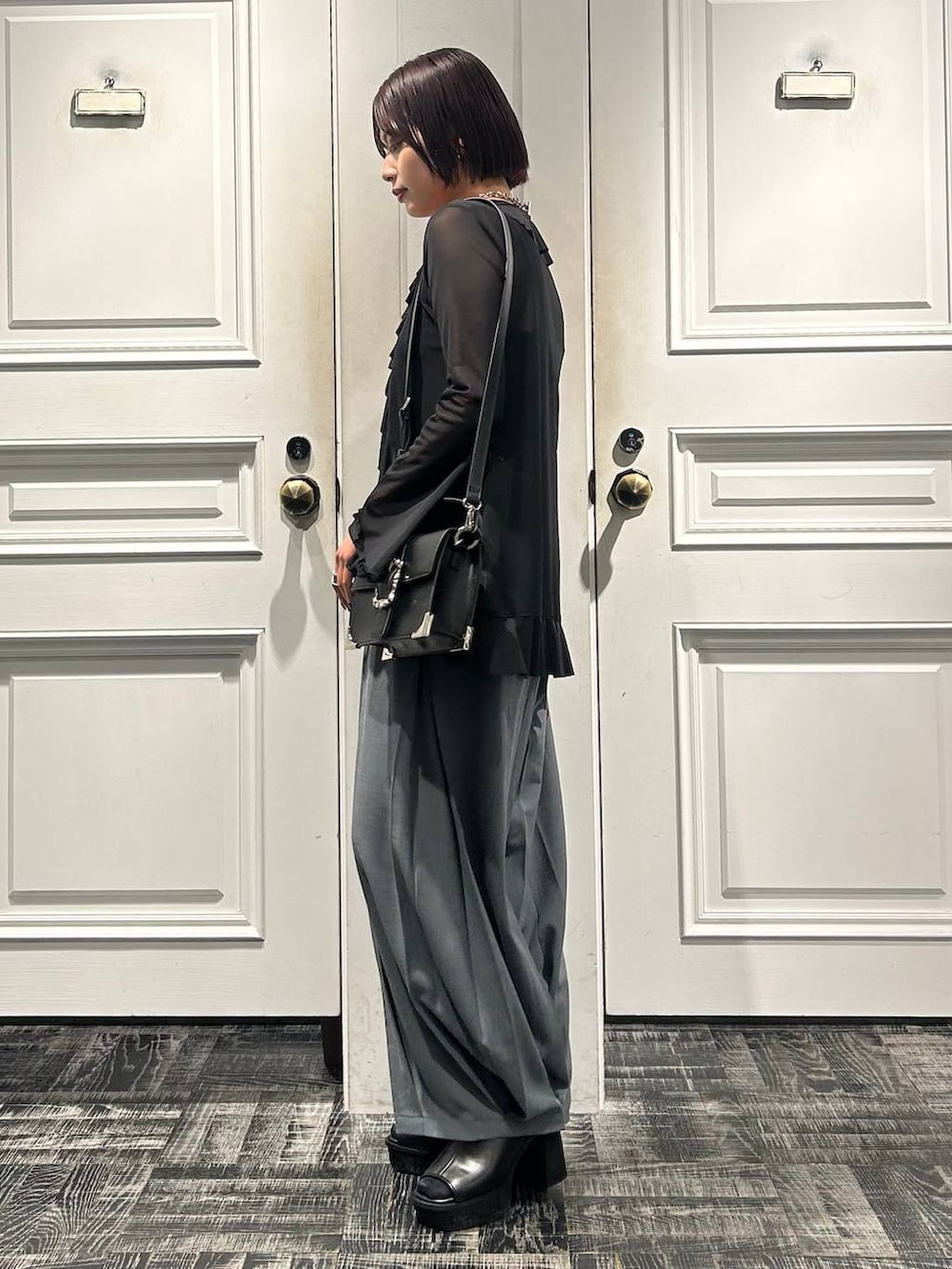 ブラック系のショルダーバッグ、グレー系のサンダル、ブラック系のカーディガン/ボレロを着用したレディースの春コーディネートの3枚目の写真