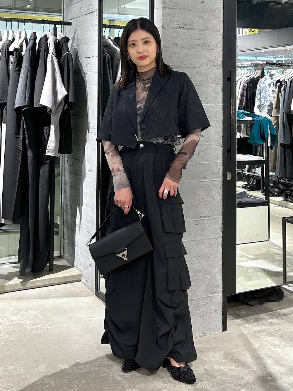 ブラック系のショルダーバッグ、ブラック系のパンプス、ブラック系のTシャツ/カットソーを着用したレディースの春コーディネートの2枚目の写真