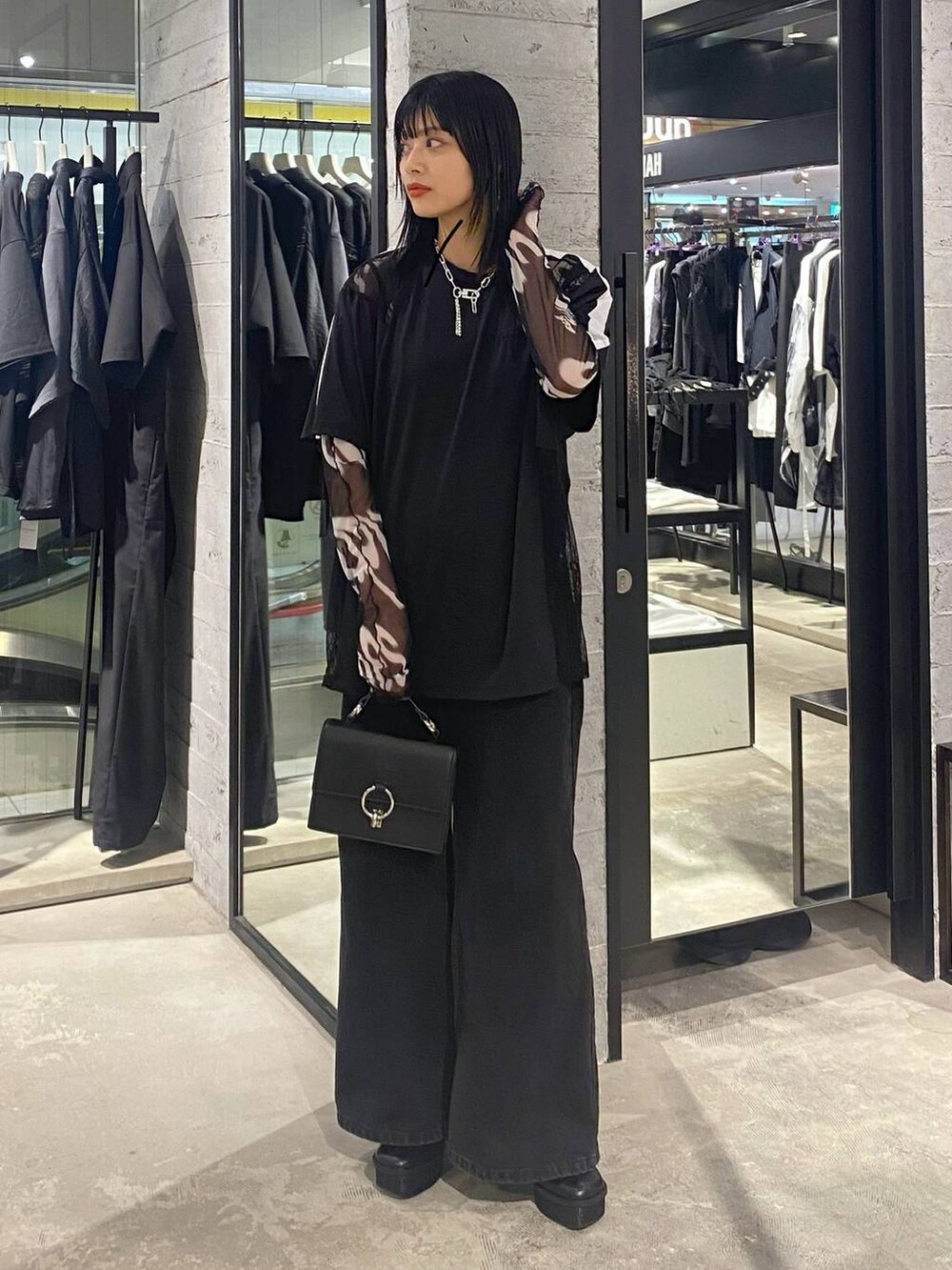 ブラック系のデニムパンツ、ブラック系のショルダーバッグ、ブラック系のパンプスを着用したレディースの夏コーディネートの2枚目の写真