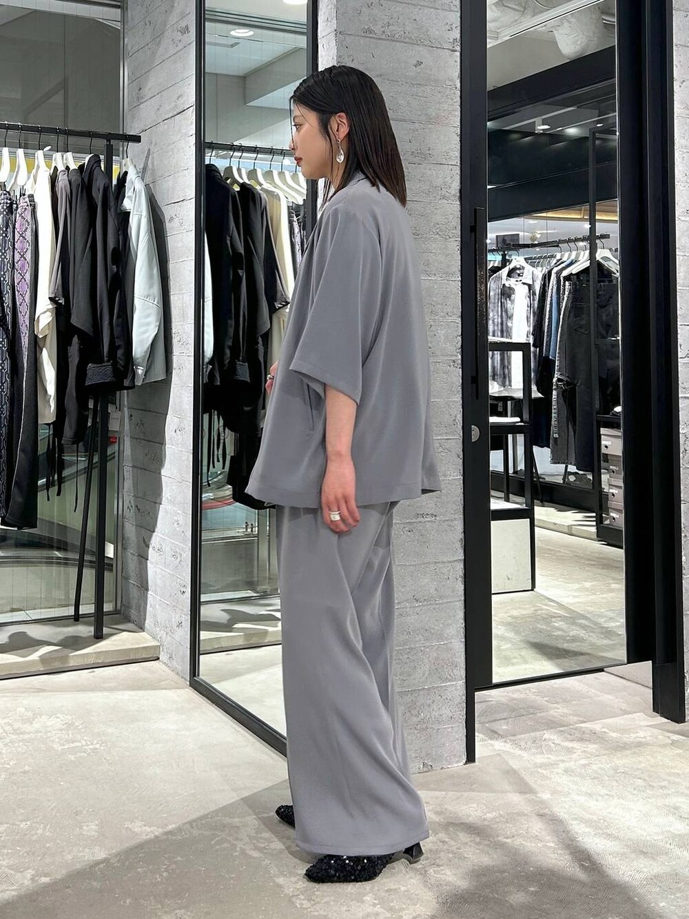 グレー系のスラックス、ブラック系のタンクトップ、ブラック系のパンプスを着用したレディースの春コーディネートの4枚目の写真