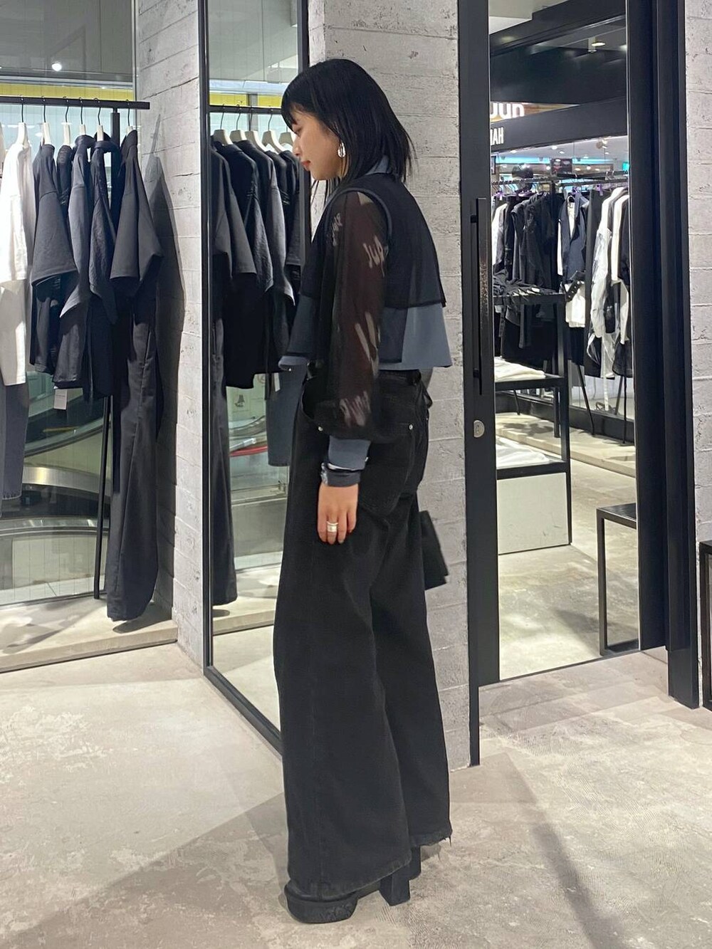 ブラック系のデニムパンツ、ブラック系のショルダーバッグ、ブラック系のパンプスを着用したレディースの夏コーディネートの3枚目の写真