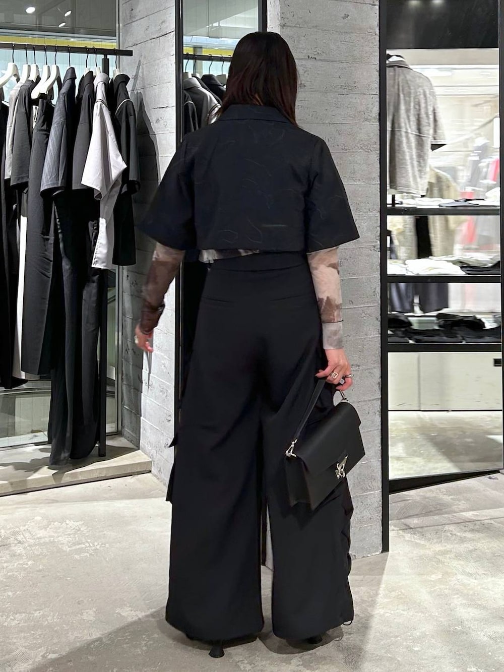 ブラック系のショルダーバッグ、ブラック系のパンプス、ブラック系のTシャツ/カットソーを着用したレディースの春コーディネートの5枚目の写真