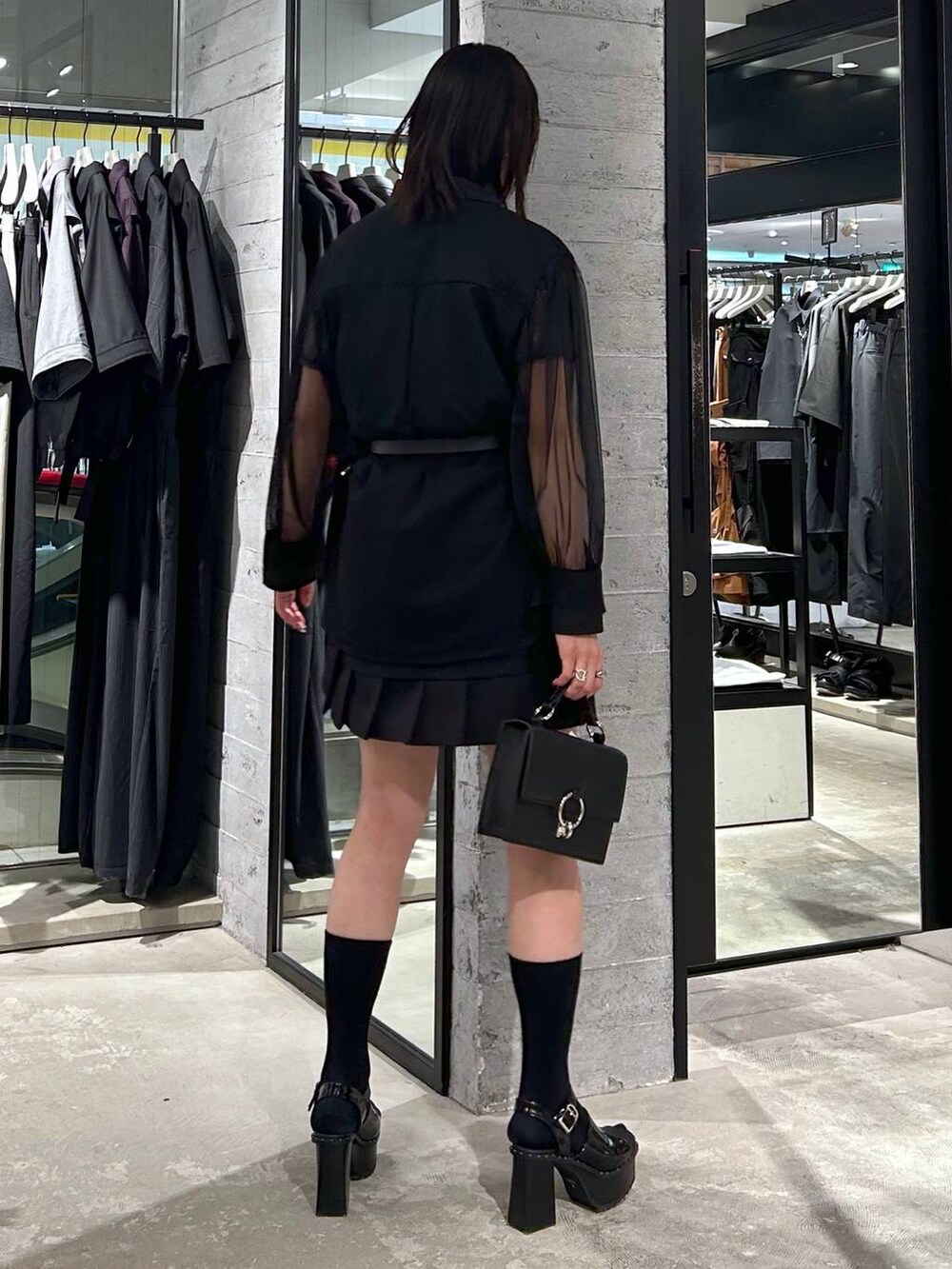 ブラック系のサンダル、ブラック系のカーゴパンツ、ブラック系のショルダーバッグを着用したレディースの春コーディネートの4枚目の写真