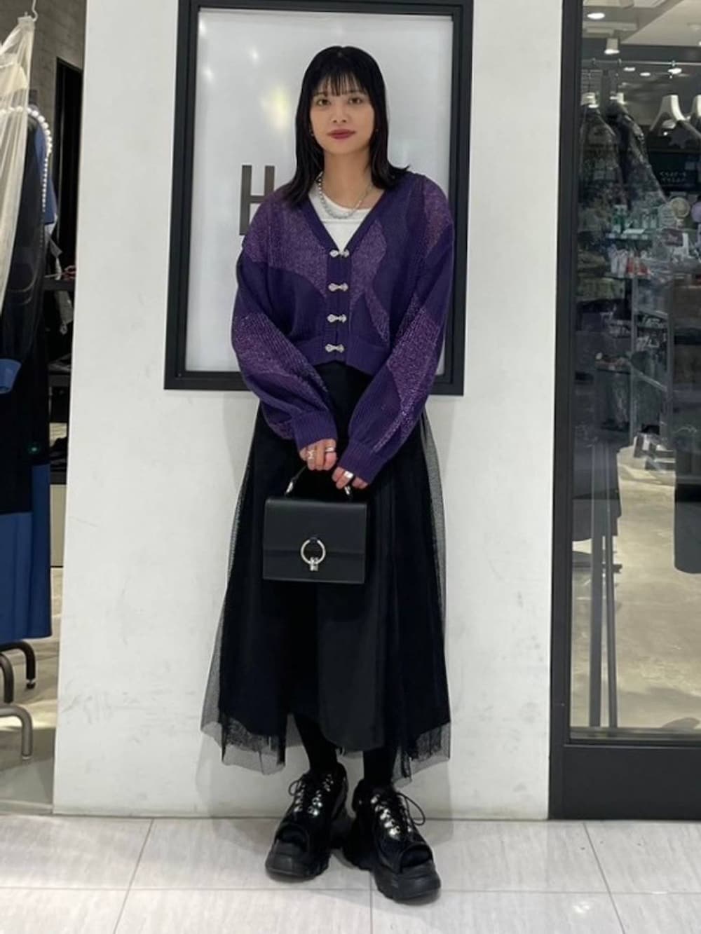 パープル系のカーディガン/ボレロ、ブラック系のショルダーバッグ、ホワイト系のタンクトップを着用したレディースの夏コーディネートの2枚目の写真