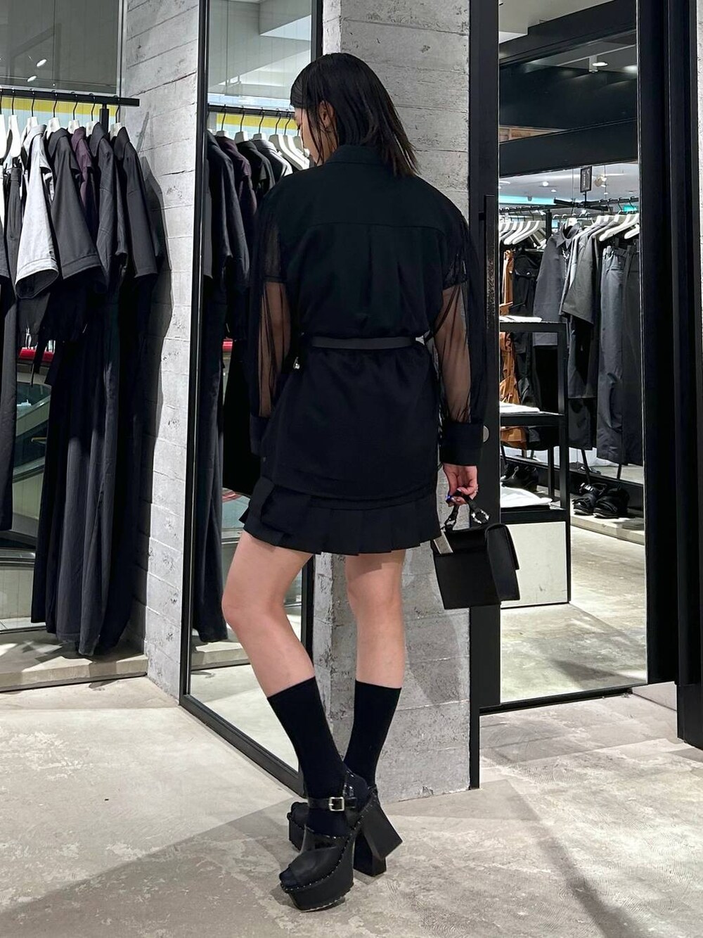 ブラック系のサンダル、ブラック系のカーゴパンツ、ブラック系のショルダーバッグを着用したレディースの春コーディネートの3枚目の写真