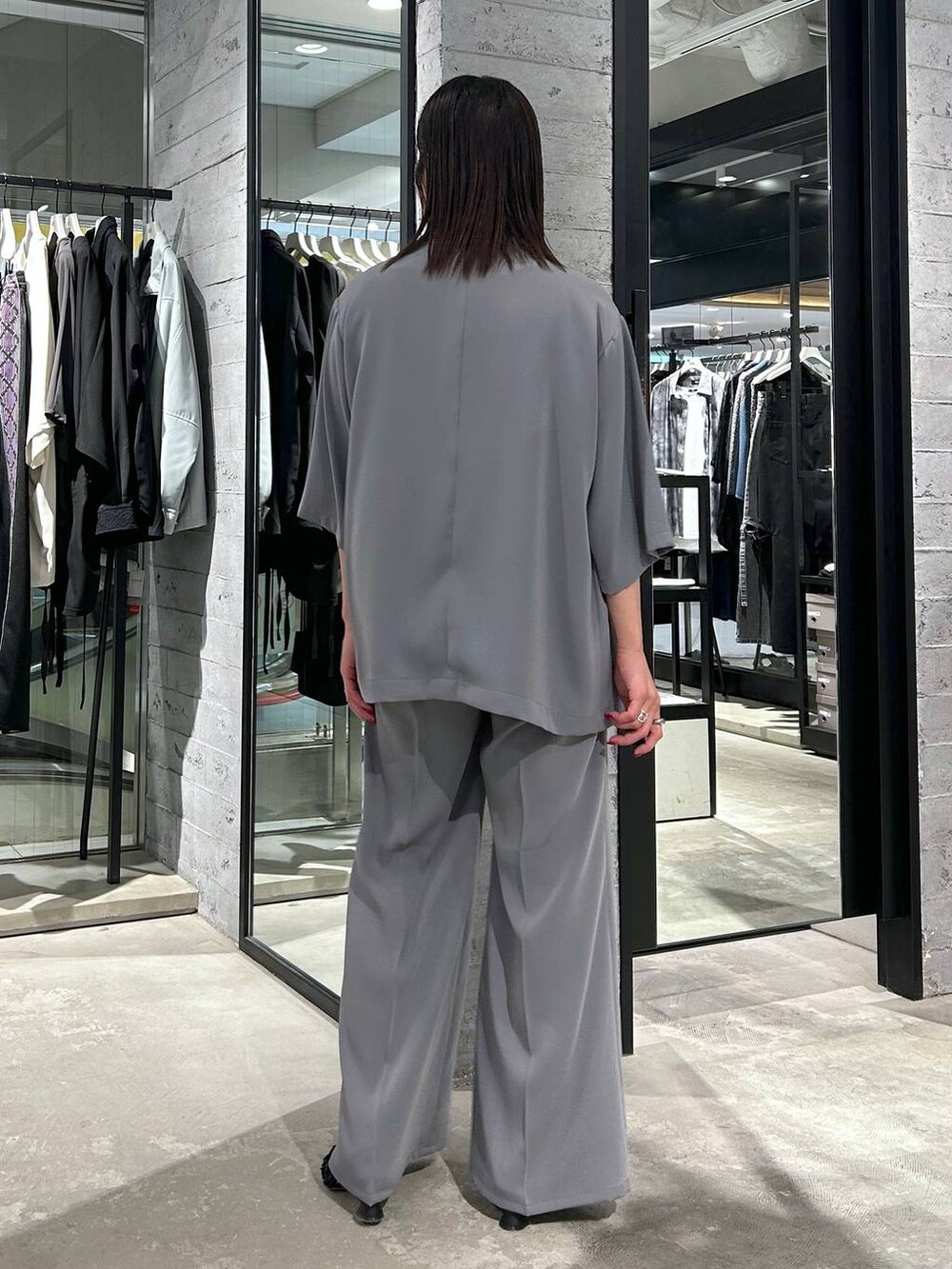 グレー系のスラックス、ブラック系のタンクトップ、ブラック系のパンプスを着用したレディースの春コーディネートの5枚目の写真