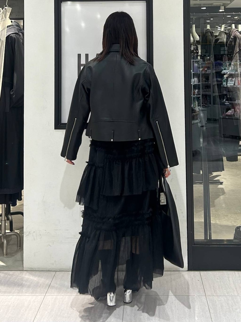 ブラック系のトートバッグ、ブラック系のニット/セーター、ブラック系のブーツを着用したレディースの秋コーディネートの5枚目の写真