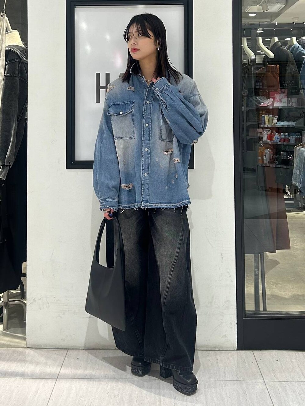 ブラック系のトートバッグ、ブラック系のデニムパンツ、ブラック系のパンプスを着用したレディースの冬コーディネートの2枚目の写真