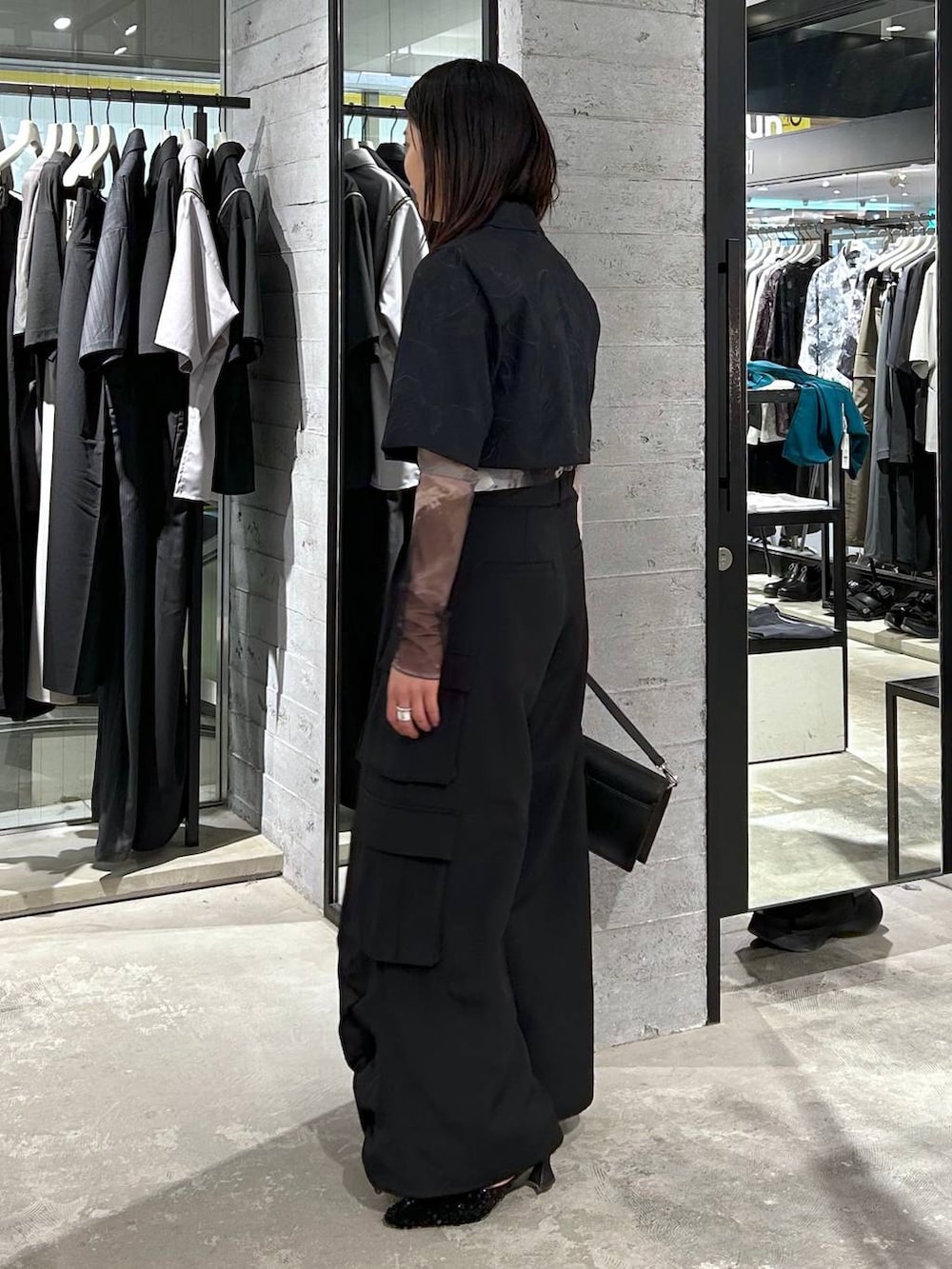 ブラック系のショルダーバッグ、ブラック系のパンプス、ブラック系のTシャツ/カットソーを着用したレディースの春コーディネートの4枚目の写真