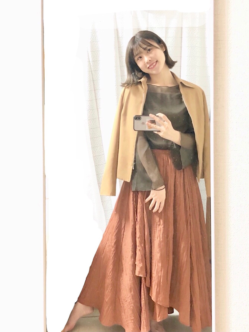 ブラウン系のシャツ/ブラウス、オレンジ系のスカート、ベージュ系のジャケット/アウターを着用したレディースの秋コーディネートの2枚目の写真