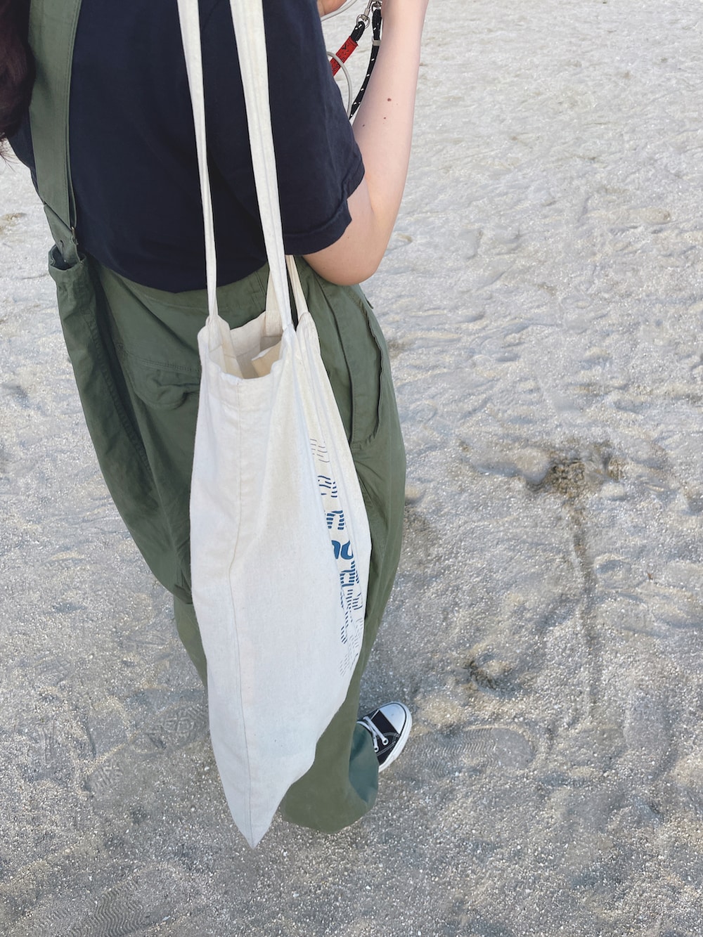 グリーン系のサロペット/オーバーオール、ブラック系のスニーカー、グリーン系のキャップを着用したレディースの春コーディネートの2枚目の写真