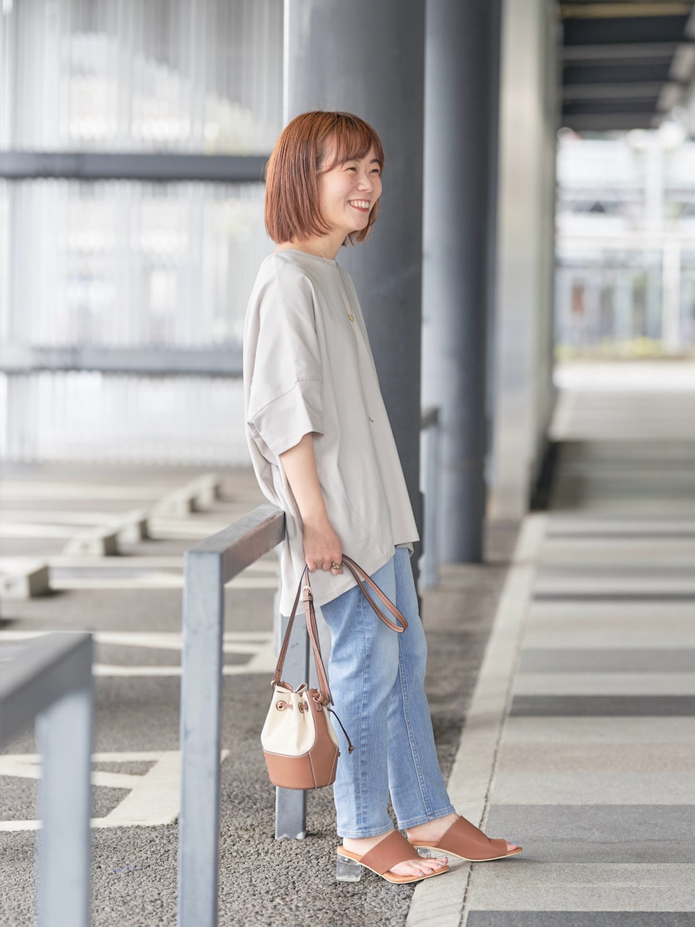 ブルー系のデニムパンツ、ベージュ系のTシャツ/カットソー、ゴールド系のネックレスを着用したレディースの春コーディネートの2枚目の写真