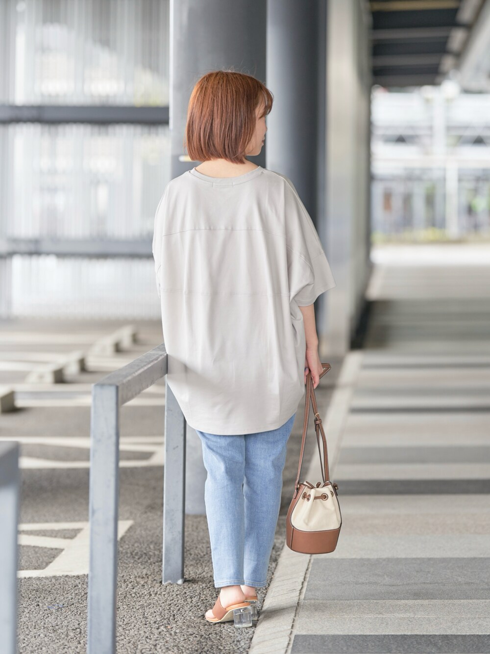 ブルー系のデニムパンツ、ベージュ系のTシャツ/カットソー、ゴールド系のネックレスを着用したレディースの春コーディネートの3枚目の写真