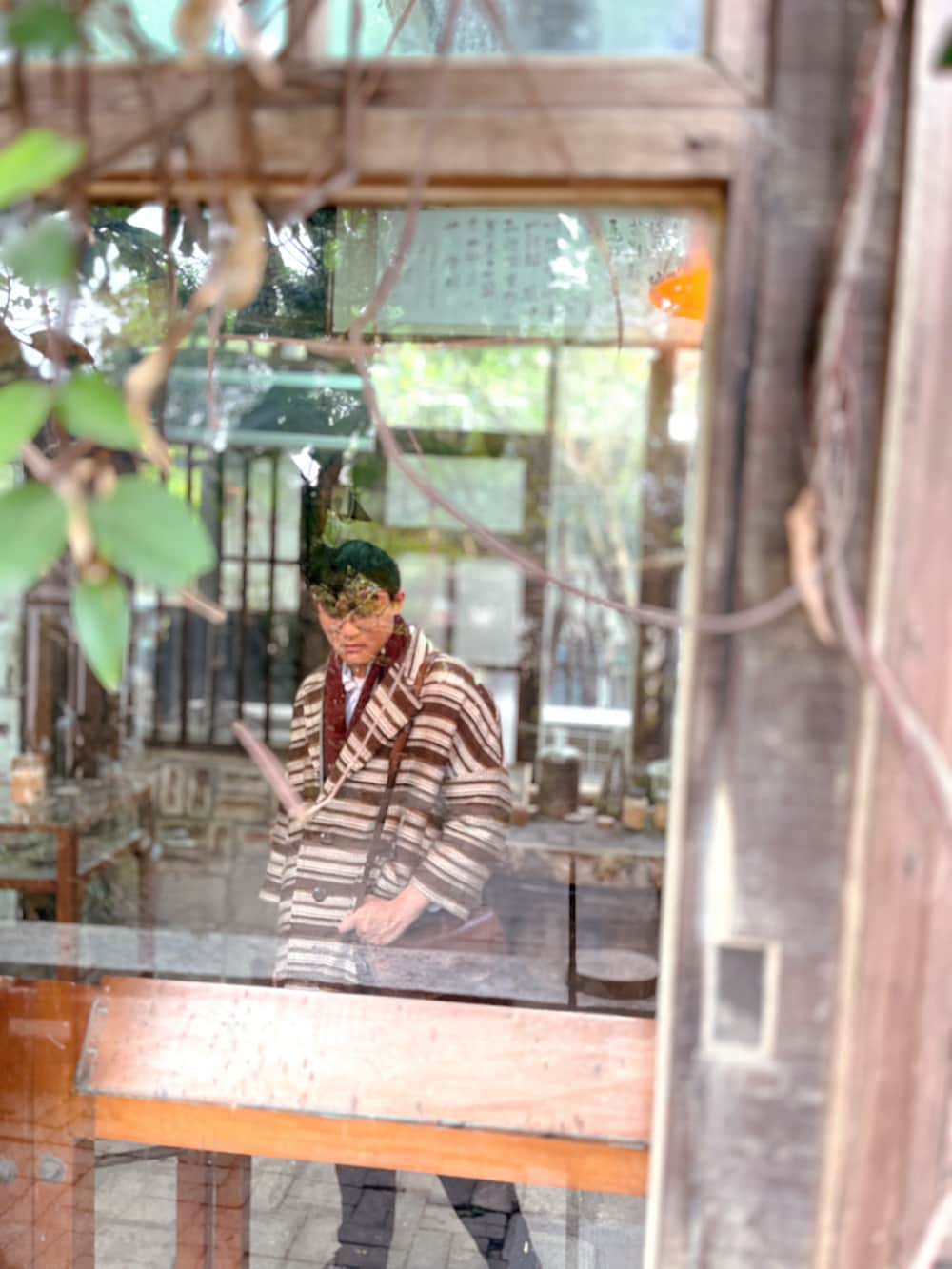 ブラウン系のビジネスバッグ、ブラウン系のピーコート、ホワイト系のシャツ/ブラウスを着用したメンズの冬コーディネートの3枚目の写真